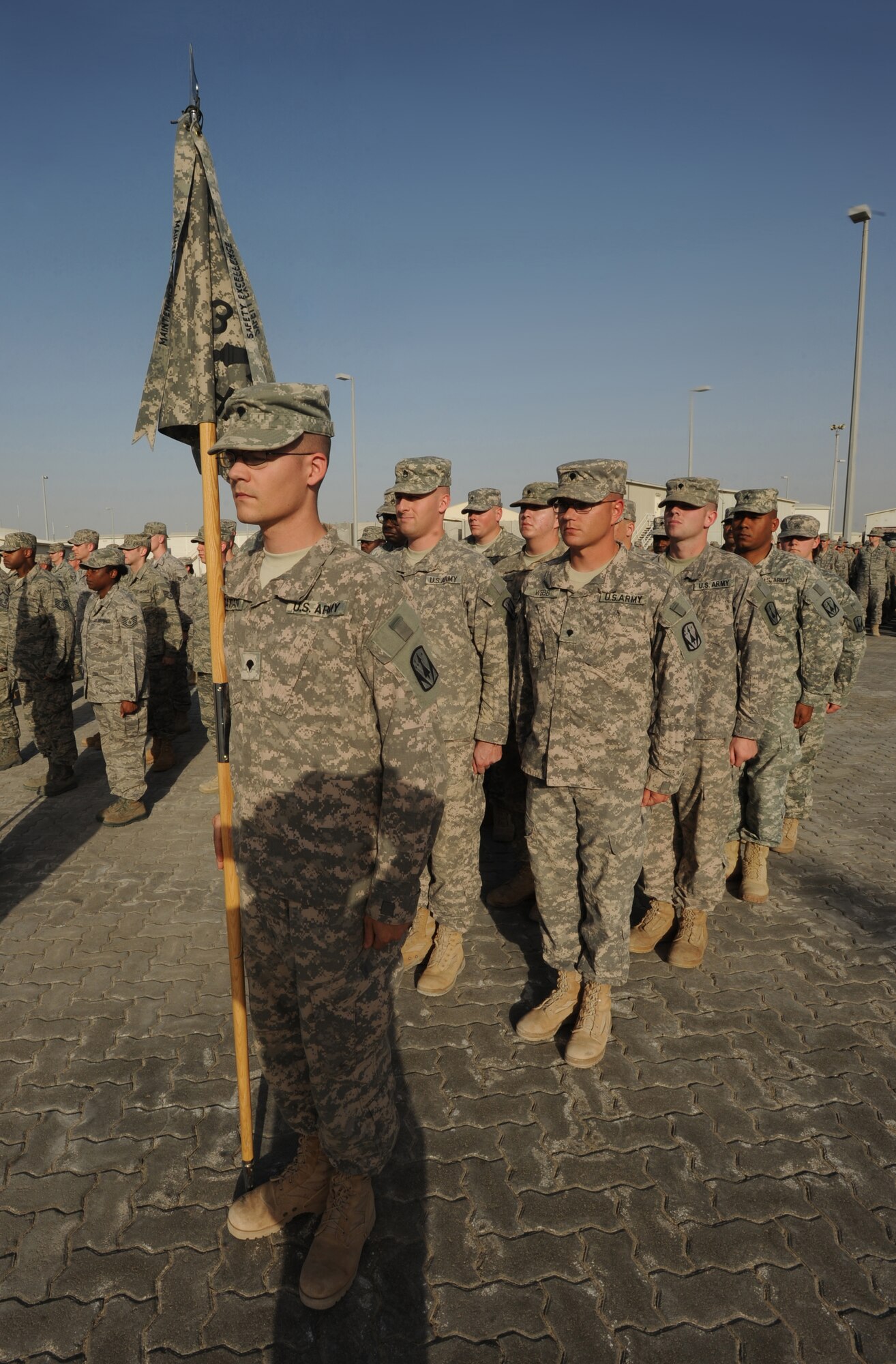 Airmen and Soldiers alike stand together during a retreat ceremony Feb. 5, 2011, in Southwest Asia. The retreat ceremony signals the end of the official duty day and serves as a ceremony to pay our respects to the flag. (U.S. Air Force photo by Senior Airman Maynelinne De La Cruz)