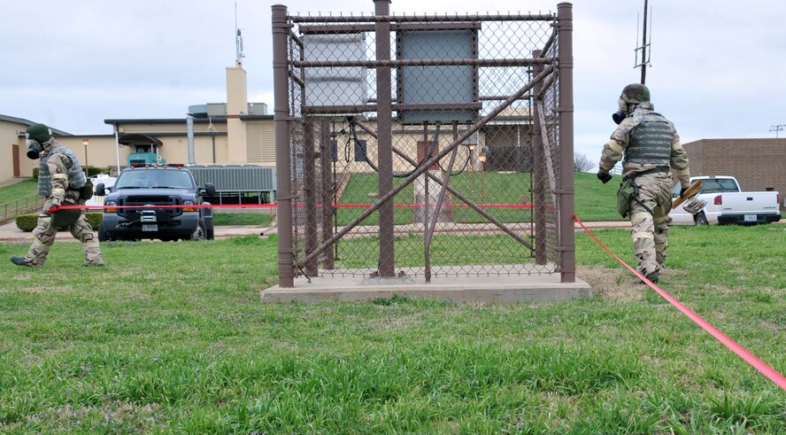 Airmen secure an area where a simulated unexploded ordnance was found during the Ability to Survive and Operate Rodeo during a Conventional Operational Readiness Exercise at Barksdale Air Force Base, La., Feb. 25. ATSO Rodeo tested the knowledge and skill of Airmen to respond to chemical attacks. (U.S. Air Force photo/Senior Airman Brittany Y. Bateman)(RELEASED)