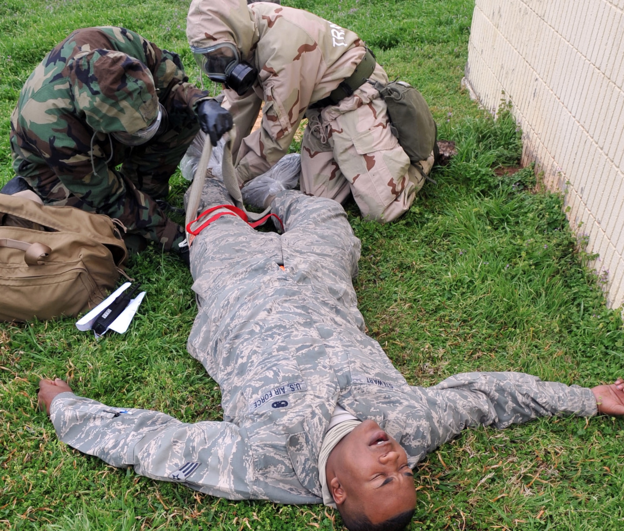 Airmen provide self aid and buddy care to Senior Airman Sterling Stewart, 2nd Maintenance Squadron during the Ability to Survive and Operate Rodeo in the Conventional Operational Readiness Exercise at Barksdale Air Force Base, La., Feb. 25. ATSO Rodeo tested the knowledge and skill of Airmen to respond to chemical attacks.  (U.S. Air Force photo/Senior Airman Brittany Y. Bateman)(RELEASED)