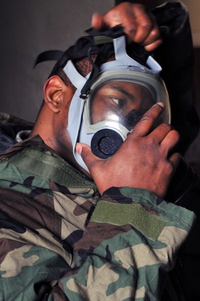 Senior Airman Rodrick Christopher, 2nd Maintenance Squadron, dons his gas mask when alarm red sounds during the Ability to Survive and Operate Rodeo as part of a Conventional Operational Readiness Exercise at Barksdale Air Force Base, La., Feb. 25. The ATSO Rodeo emphasized contamination control, unexploded ordnance identification, self aid and buddy care and marking and asset protection in a chemical environment. (U.S. Air Force photo/Senior Airman Brittany Y. Bateman)(RELEASED)
