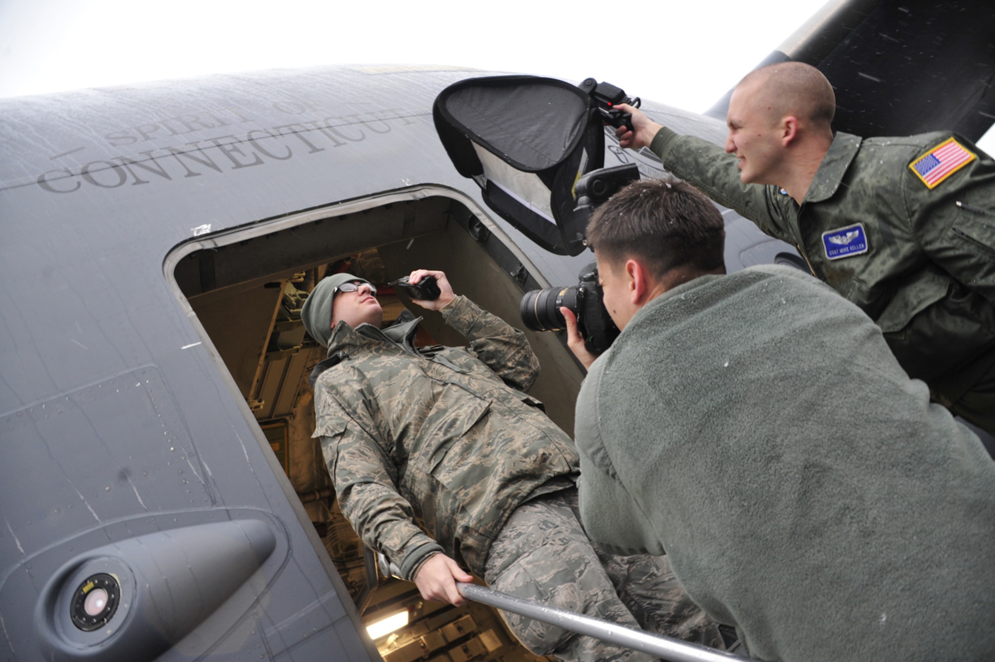 Staff Sgt. Mike Keller, right, and Staff Sgt. Chad Trujillo, center, both 1st Combat Camera Squadron photographers from Joint Base Charleston, S.C., take photographs of Senior Airman Jon Taylor, left, 62nd Aircraft Maintenance Squadron equipment custodian, Feb. 23 at Joint Base Lewis-McChord, Wash. Sergeants Keller and Trujillo are photographing Air Mobility Command Airmen all over the command in support of the "Celebrating Mobility Airmen Project." (U.S. Air Force photo/Airman 1st Class Leah Young)

