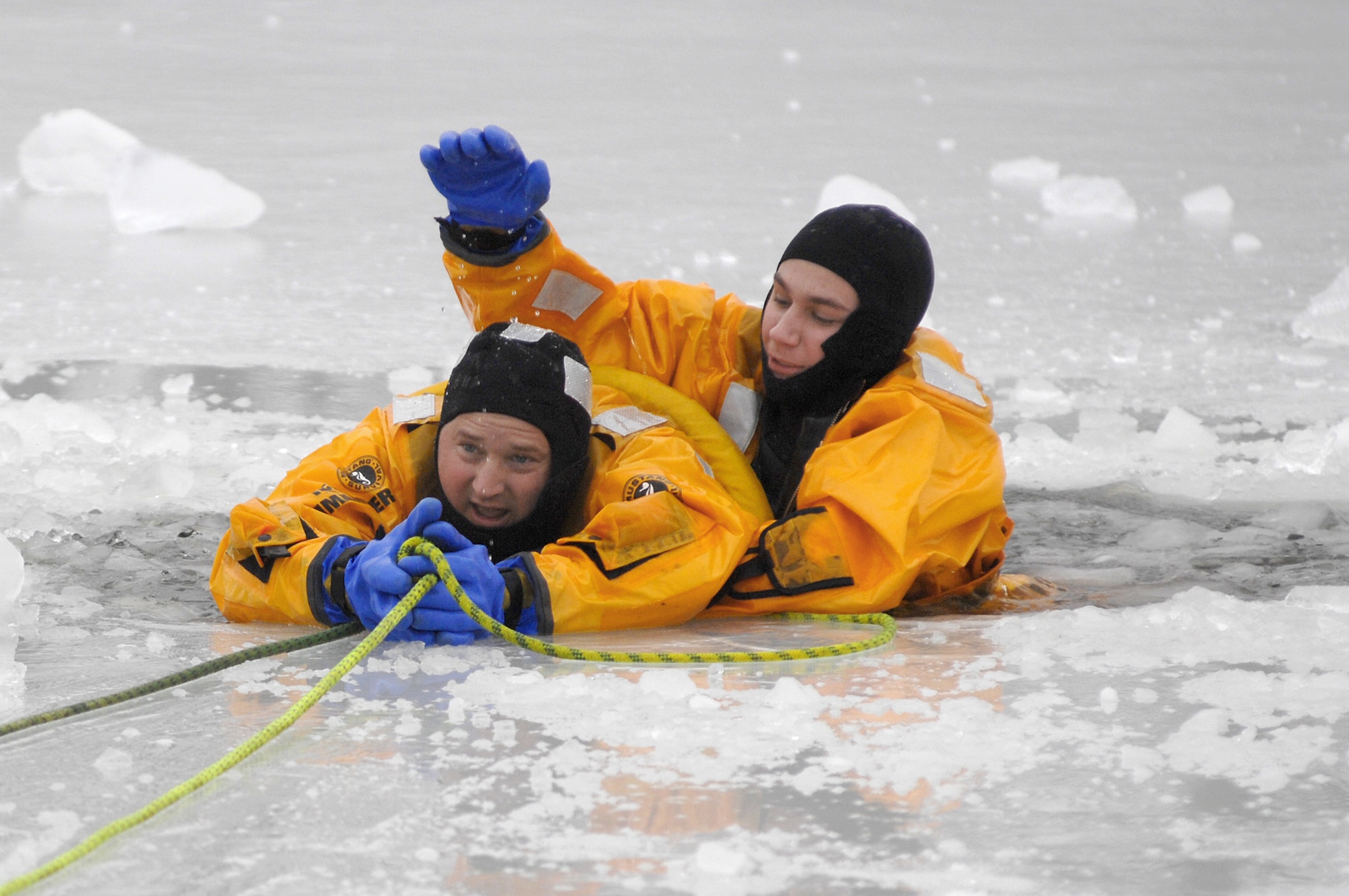 Two 509th Civil Engineer Squadron members are pulled from an icy hole during ice rescue training Jan. 31, 2011, at Whiteman Air Force Base, Mo. (U.S. Air Force photo/Senior Airman Kenny Holston)
