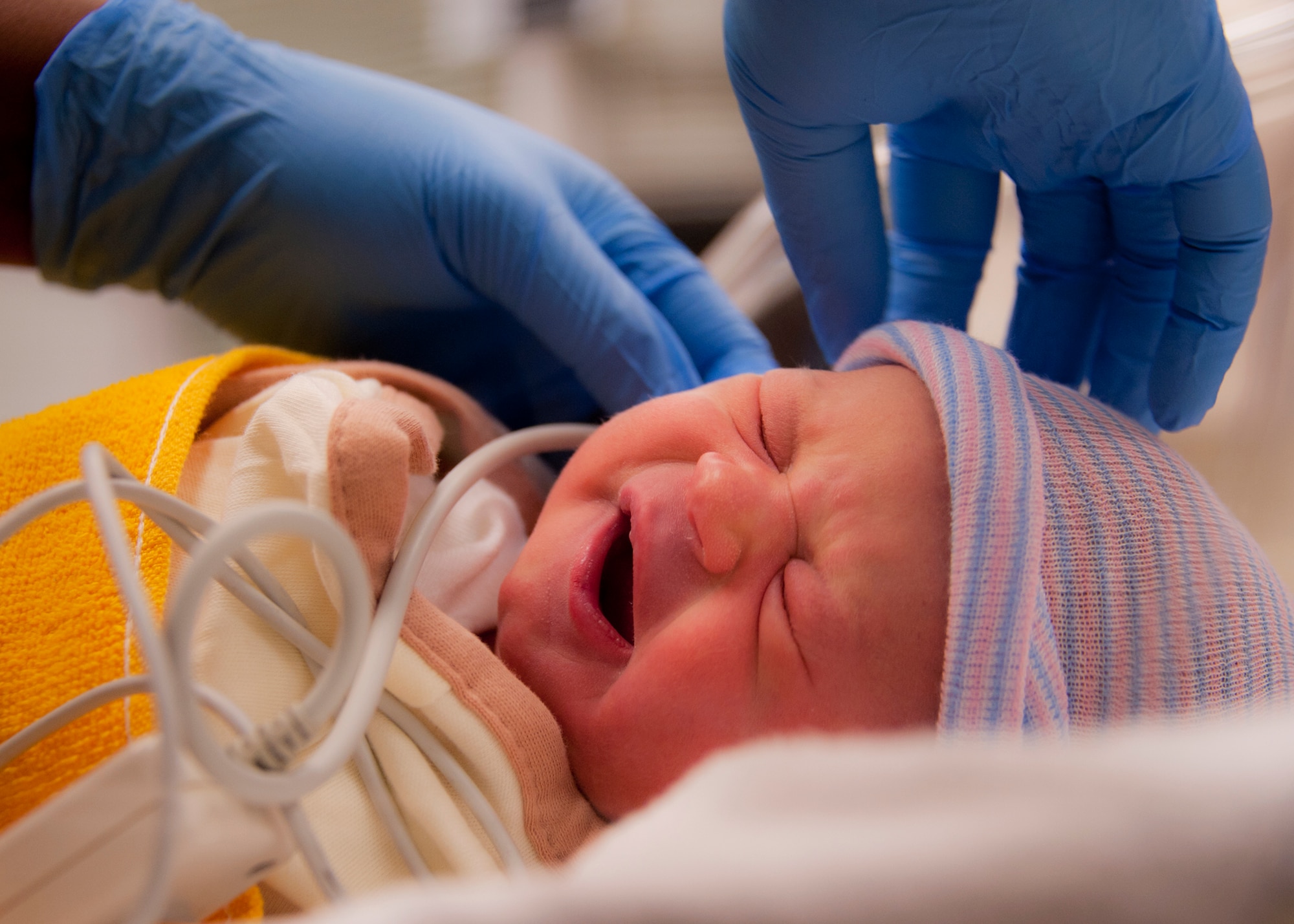 Sarah Thompson, daughter of Senior Airman Josh Thompson, 1st Special Operations Wing, yawns as she undergoes a newborn hearing screening approximately 24 hours after her birth.  The screening measures otoacoustic emissions, which are sounds produced by the outer hair cells within the inner ear. It is common practice for babies born on base and a state-mandated procedure in Florida.  (U.S. Air Force photo/Samuel King Jr.)