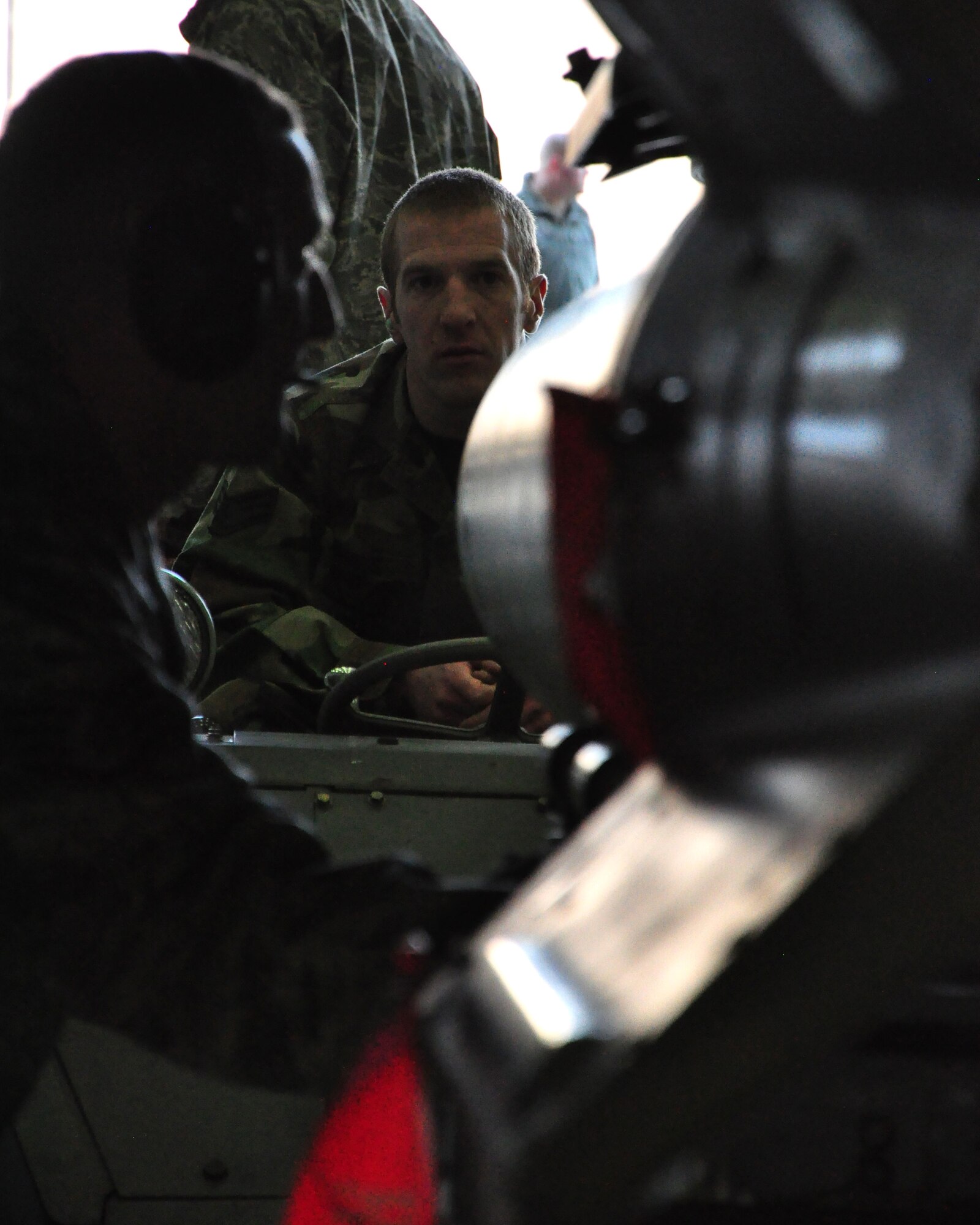 Senior Airman Joshua Gross maneuvers an air-to-ground bomb in place while Staff Sgt. Ryan Skuller, spots him for safety during a weapons loading competition for the best load crew of the year in a hangar at Osan Air Base, Republic of Korea, Feb. 25. Both Airmen are with the 51st Aircraft Maintenance Squadron (U.S. Air Force photo/Staff Sgt. Chad Thompson).