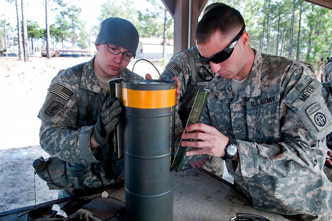 Army Sgt. Michael Mark, left, and Pfc. Levi Meyer attach C4 explosives to a detonation charge on Fort Bragg, N.C., Feb. 23, 2011. Mark is a combat engineer and Meyer is a medic assigned to the 82nd Airborne Division’s 1st Brigade Combat Team. 