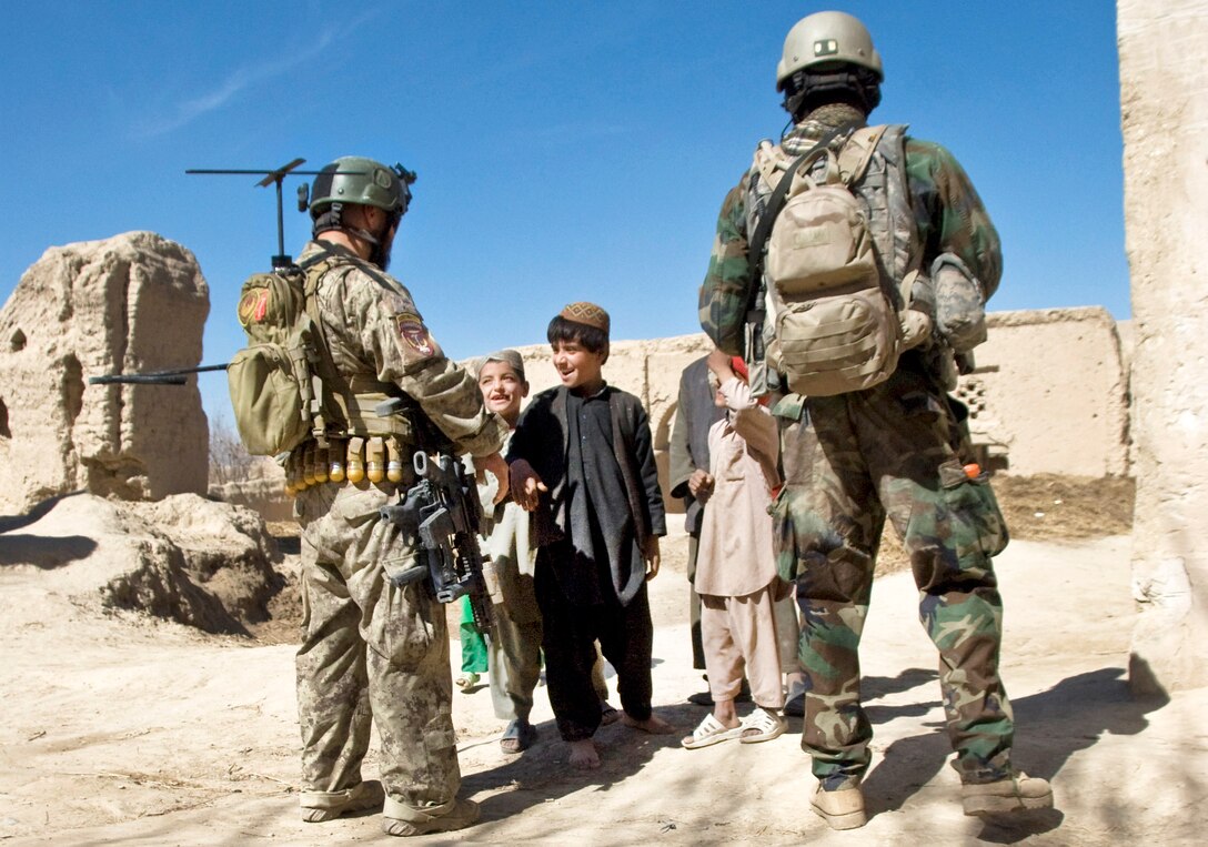 A U.S. Special Forces soldier greets Afghan children in Kandahar province, Afghanistan, Feb. 20, 2011.