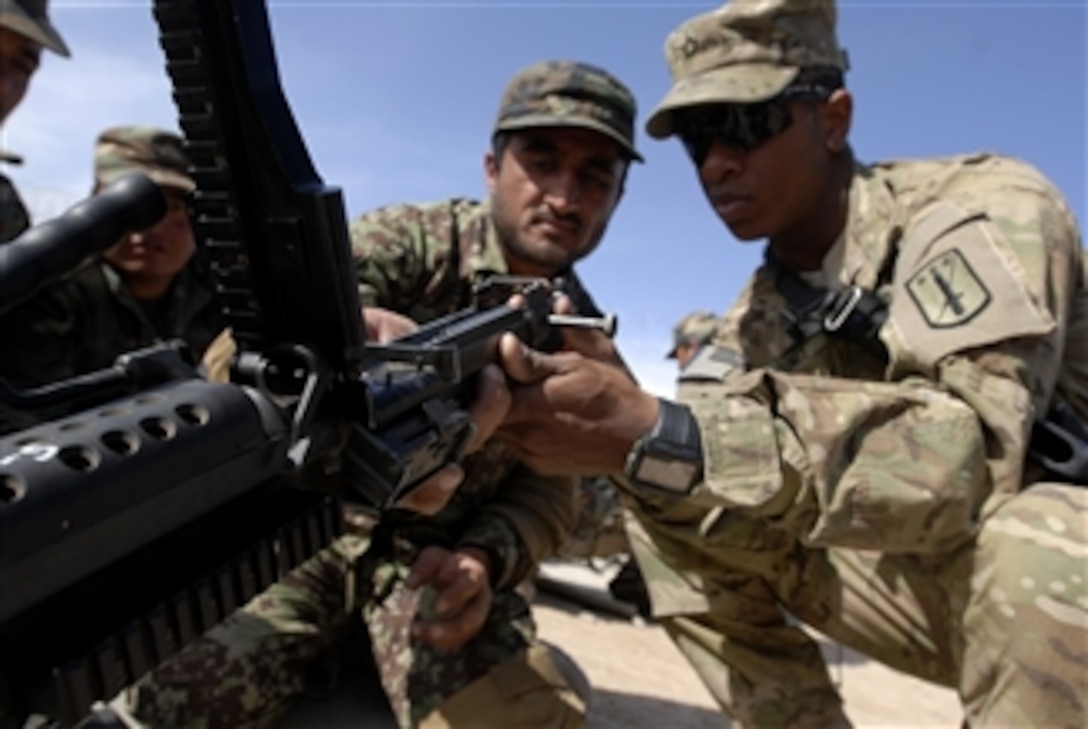 U.S. Army Pfc. Jeremiah Jones (right), with Bravo Company, 3rd Battalion, 4th Infantry Regiment, 170th Infantry Brigade, shows an Afghan National Army recruit how to disassemble a M240B machine gun during weapons training at Basic Warrior Training at Regional Military Training Center, Kandahar province, Afghanistan, on Feb. 22, 2011.  The recruits performed basic maintenance skills on these weapons before taking them to a weapons range.  