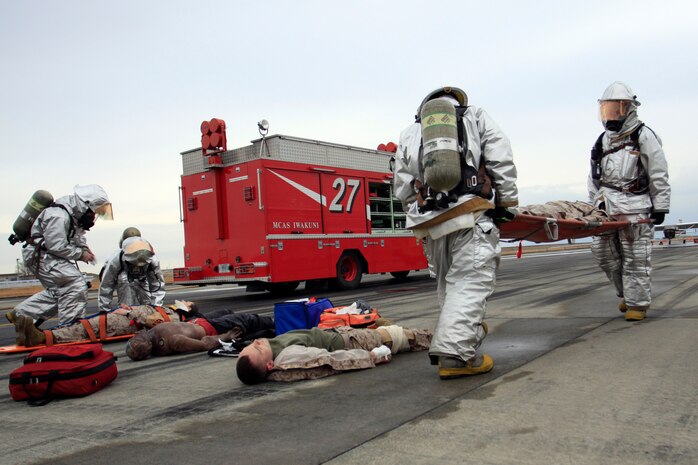Marines with Aircraft Rescue Firefighting tend to injured victims during a simulated emergency crash landing on the southern end of the old runway here during Active Shield 2011. In the scenario, a U.S. C-12 Cessna was shot down on final approach of the runway by an anti aircraft missile from an unknown location.