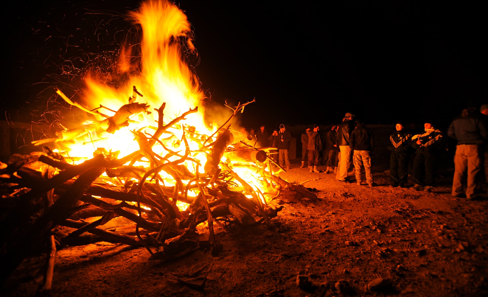 Airmen, Soldiers and U.S. civilians from Provincial Reconstruction Team Zabul socialize with local Afghans around a bonfire just after midnight, on New Year's Day at Forward Operating Base Smart, Afghanistan.  (U.S. Air Force photo/Staff Sgt. Brian Ferguson)