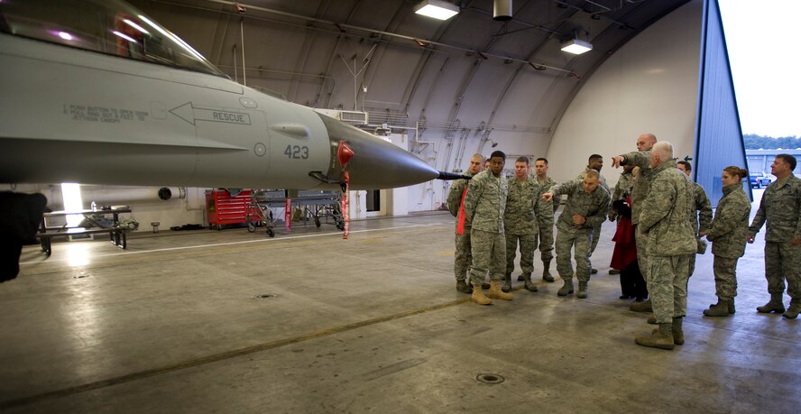 U.S. Air Force Tech. Sgt. Jarid Morris (right, pointing), 14th Aircraft Maintenance Unit avionics technician, identifies parts of the F-16 Fighting Falcon for Chief Master Sgt. of the Air Force James Roy (left, pointing) in a hardened aircraft shelter, Misawa Air Base, Japan, Dec. 28, 2010. At the end of the visit, Chief Roy gave Sergeant Morris a challenge coin for his hard work. (U.S. Air Force photo by Staff Sgt. Samuel Morse/Released)