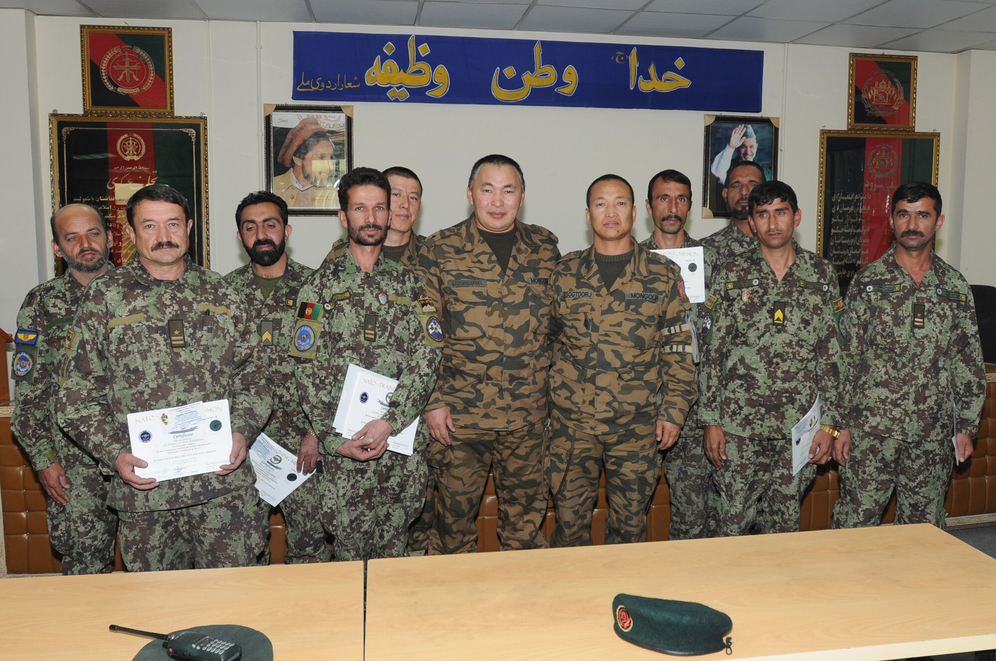 KABUL, Afghanistan – Afghan Air Force and Mongolian Air Force Airmen pose for a photograph after a graduation ceremony honoring the completion of the Mi-17 helicopter engine and body maintenance course at the Afghan Air Force Base in Kabul, Afghanistan Jan. 1. The ten Airmen who graduated on Jan. 1 become the first troops to complete the course, one seen as critical by AAF officials as the Mi-17 assumes its position as the centerpiece of the force. (U.S. Navy photo by Mass Communications Specialist Second Class Vladimir Potapenko/RELEASED).