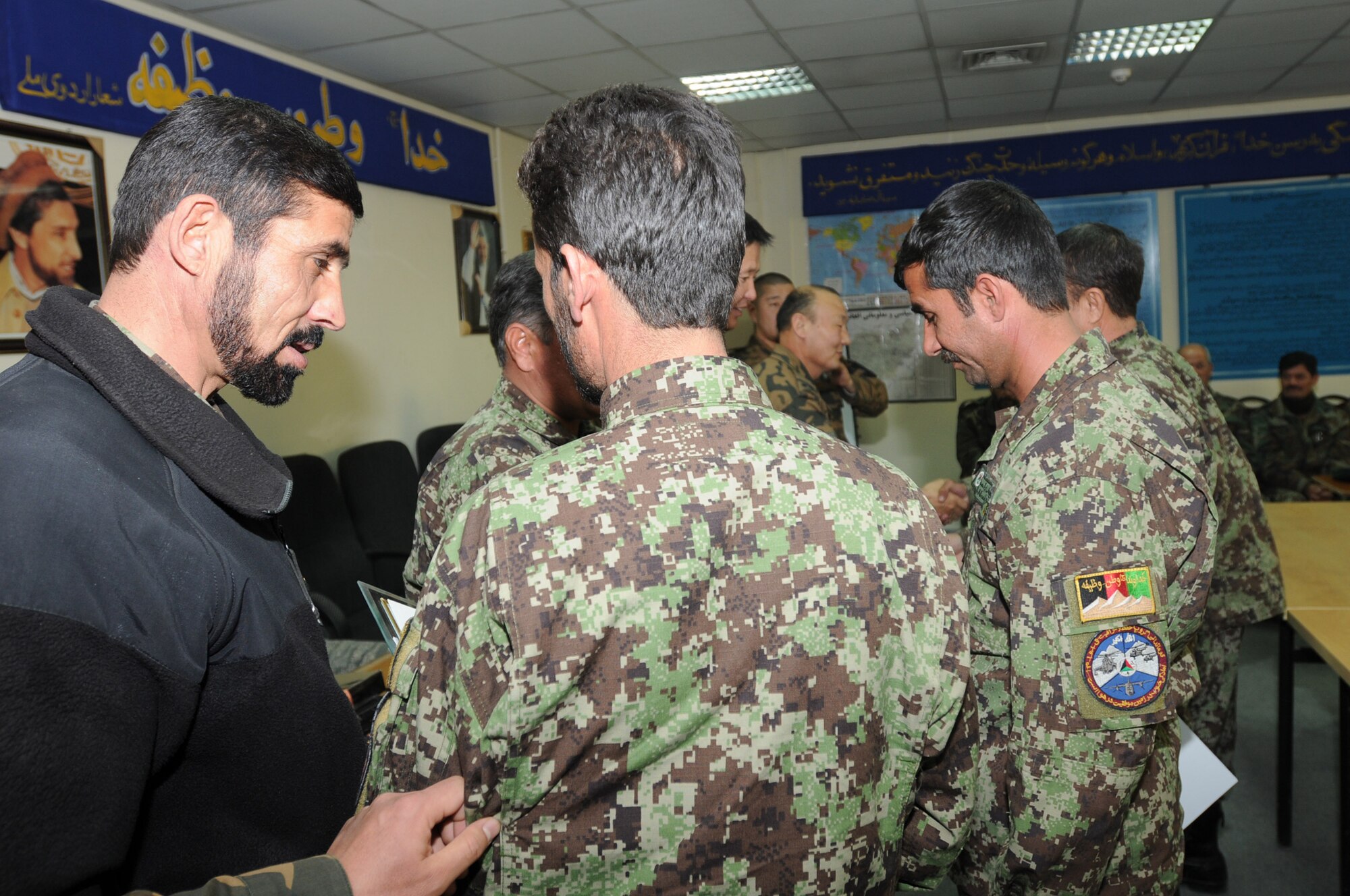 KABUL, Afghanistan – An Afghan Air Force Airman is congratulated for graduating from the Mi-17 helicopter engine and body maintenance course at the Afghan Air Force Base in Kabul, Afghanistan Jan. 1. The ten Airmen who graduated on Jan. 1 become the first troops to complete the course, one seen as critical by AAF officials as the Mi-17 assumes its position as the centerpiece of the force. (U.S. Navy photo by Mass Communications Specialist Second Class Vladimir Potapenko/RELEASED).