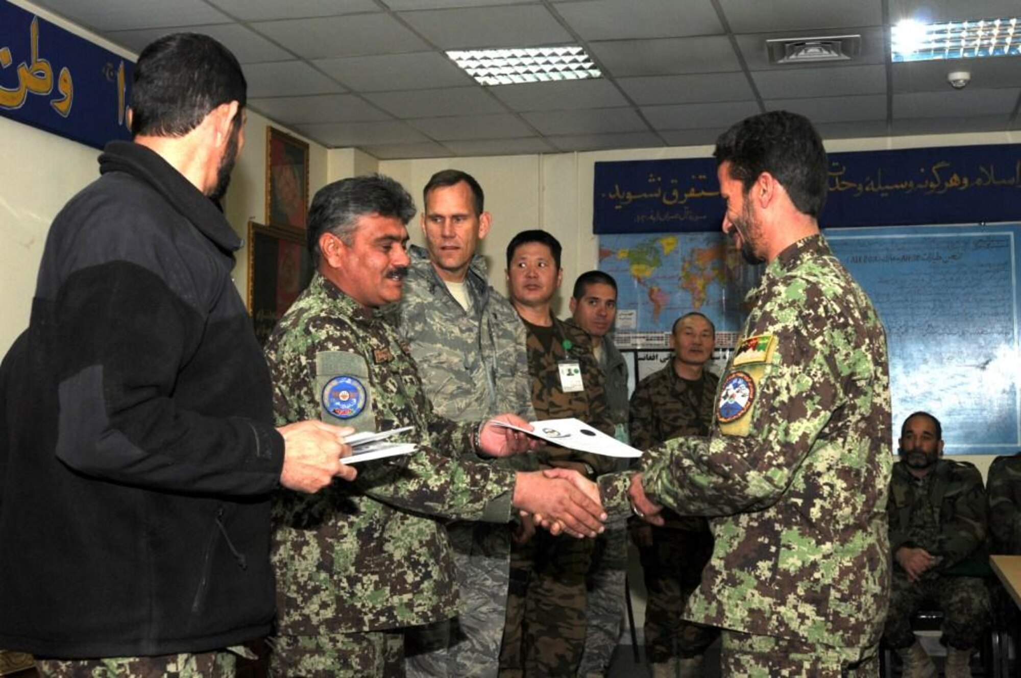 KABUL, Afghanistan – An Afghan Air Force Airman receives a certificate for graduating from the Mi-17 helicopter engine and body maintenance course at the Afghan Air Force Base in Kabul, Afghanistan Jan. 1. The ten Airmen who graduated on Jan. 1 become the first troops to complete the course, one seen as critical by AAF officials as the Mi-17 assumes its position as the centerpiece of the force. (U.S. Navy photo by Mass Communications Specialist Second Class Vladimir Potapenko/RELEASED).