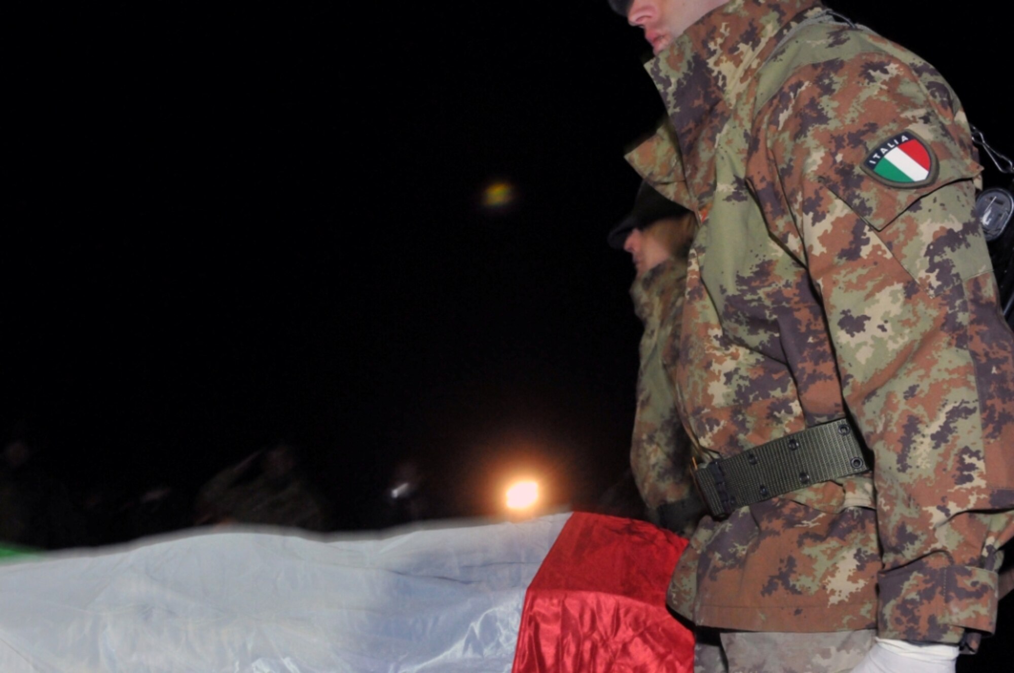 The flag-draped transfer case of Corporal Major (E-4) Matteo Miotto, an Italian soldier killed in western Farah Province, Afghanistan, arrives at Camp Arena, Herat Province Dec. 31, 2010. Miotto’s remains were returned to Rome Jan. 1. (U.S. Air Force photo/Tech. Sgt. Kevin Wallace)