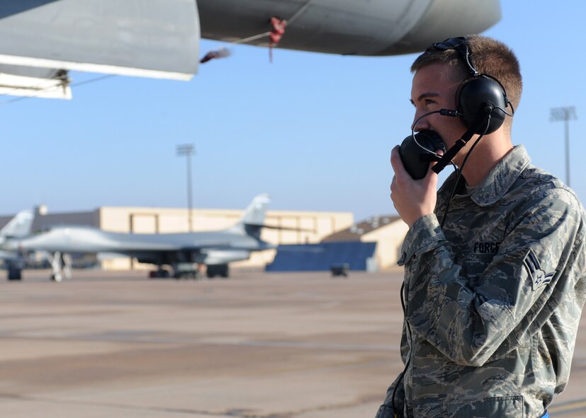 DYESS AIR FORCE BASE, Texas -- Airman 1st Class Jason woody, 7th Aircraft Maintenance Squadron, ensures ground safety as the B-1 Bomber auxiliary power units run here, Dec. 29. Airman Woody is an electronic warfare technician who is responsible for operating and maintaining avionics systems. He fixes malfunctions in avionics systems, radar, integrated test systems built-in-test, recording systems, video display systems and various other systems. (U.S. Air Force photo/Senior Airman Jenifer H. Calhoun)