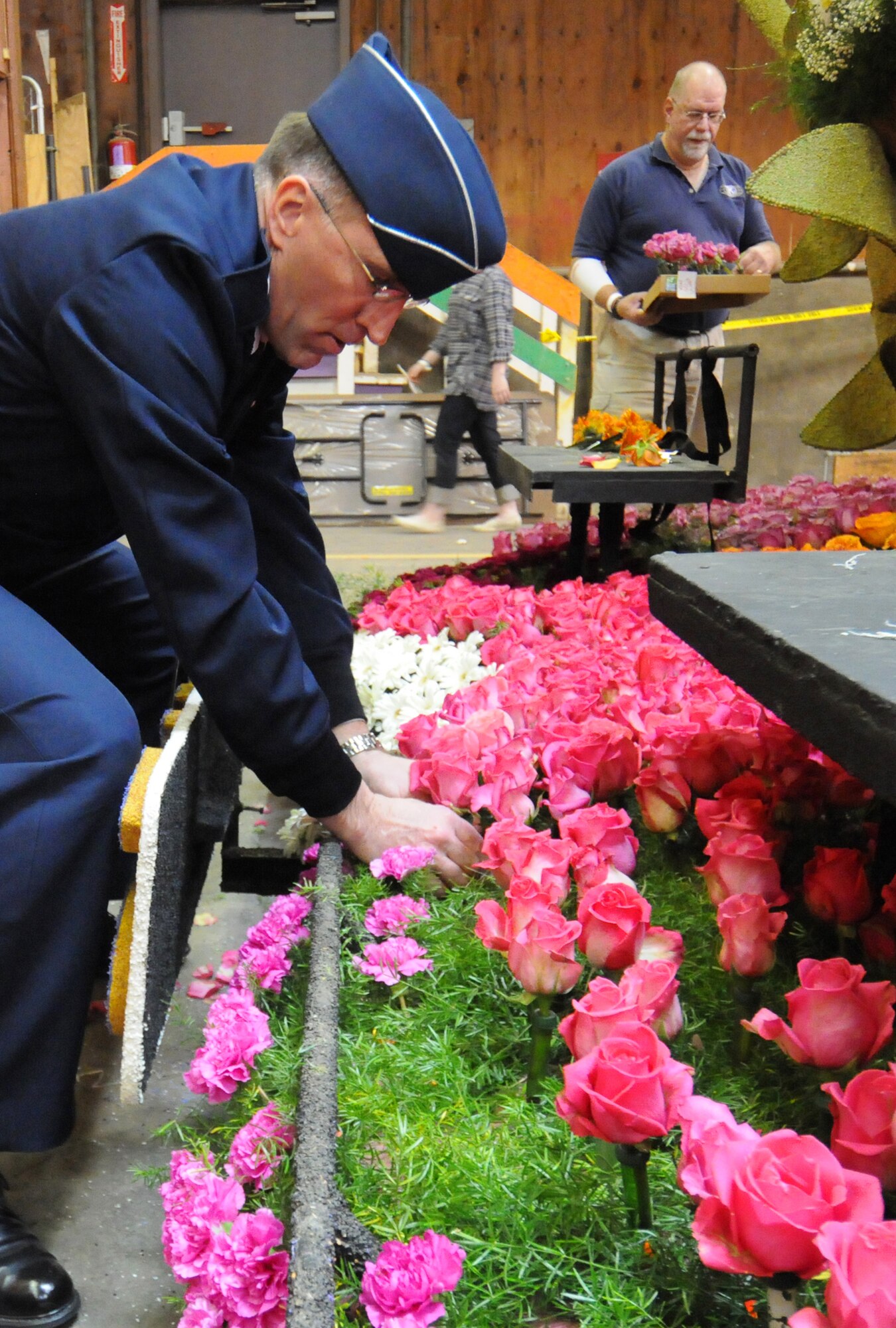 Brig. Gen. Scott Vander Hamm, Commander of the 509th Bomber Wing, Whiteman Air Force Base, Mo., places a rose on a parade float while visiting the Tournament of Roses' Decorating Places Dec. 31, 2010. A B-2 performed the flyover over this year's 122nd annual parade. (Photo by Joe Juarez)
