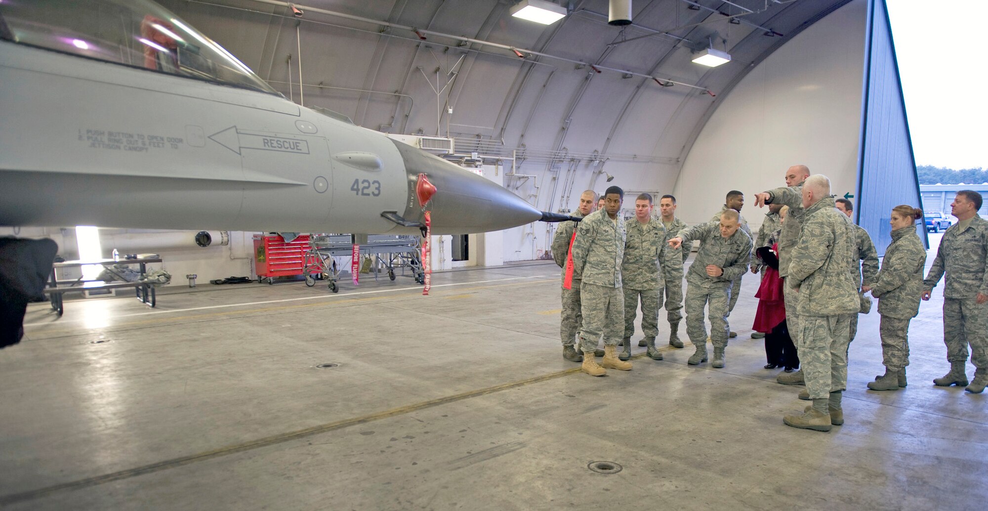 Tech. Sgt. Jarid Morris (right, pointing) identifies parts of an F-16 Fighting Falcon for Chief Master Sgt. of the Air Force James A. Roy (left, pointing) Dec. 28, 2010, in a hardened aircraft shelter at Misawa Air Base, Japan. At the end of the visit, Chief Roy gave Sergeant Morris a challenge coin for his hard work. Sergeant Morris is an avionics technician with the 14th Aircraft Maintenance Unit. (U.S. Air Force photo/Staff Sgt. Samuel Morse)