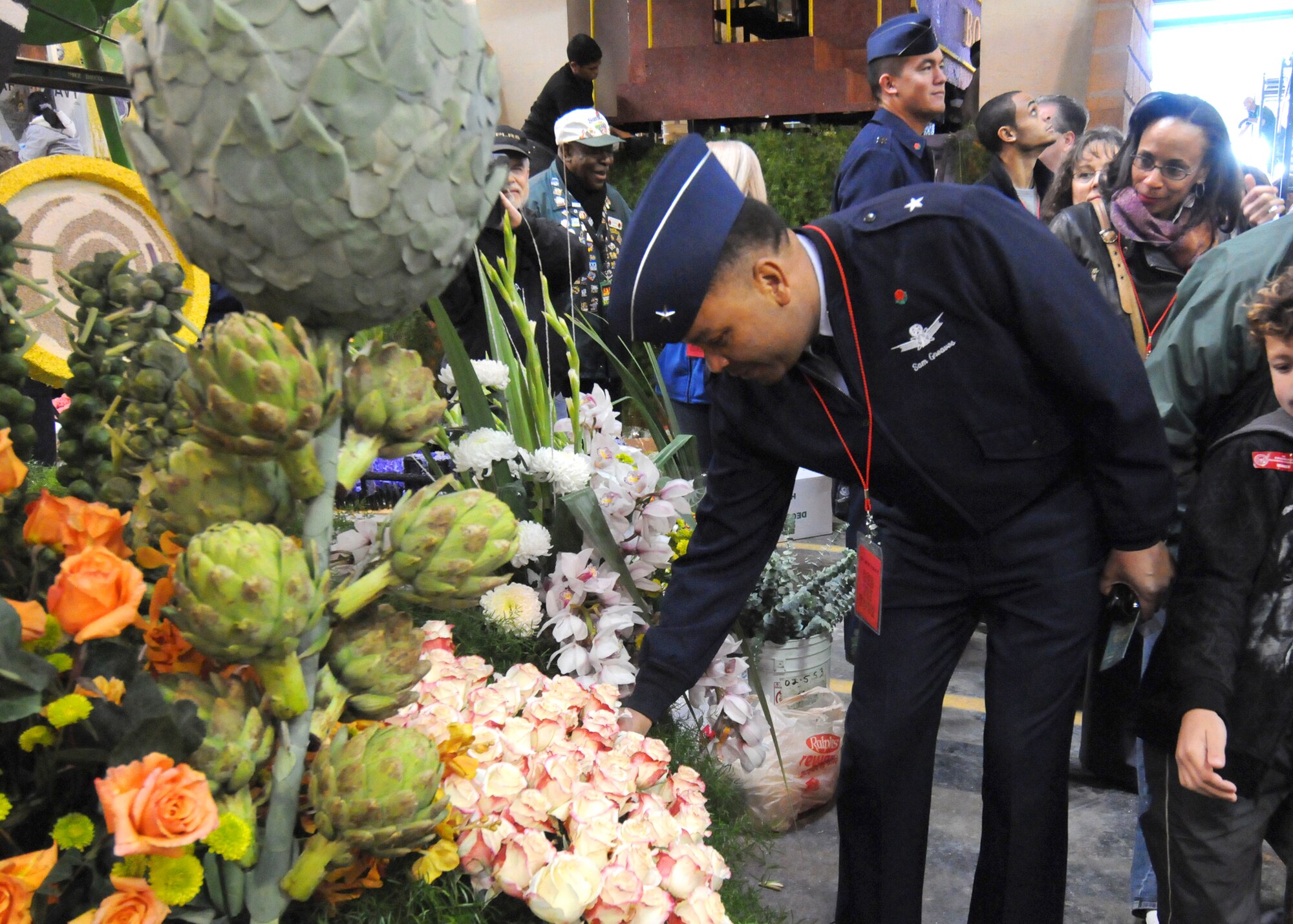 Brig. Gen. Sam Greaves, Vice Commander of the Space and Missile Systems Center, Los Angeles Air Force Base, places a flower on a float while visiting Decorating Places at the 2010's Tournament of Roses Dec. 31, 2010. (Photo by Joe Juarez)