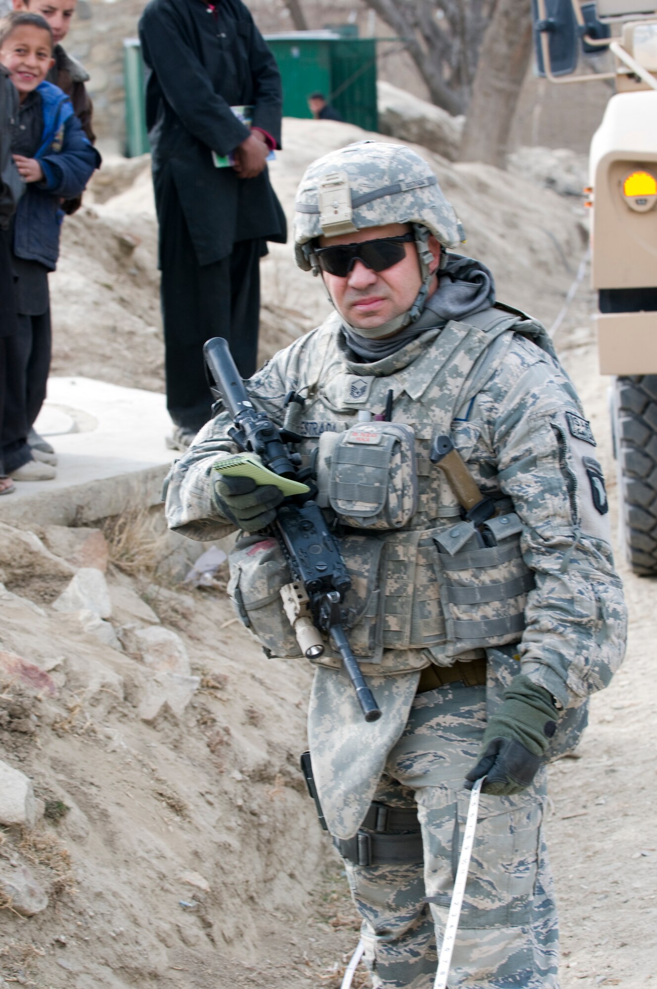 KAPISA PROVINCE, Afghanistan – U.S. Air Force Master Sgt. Jonathan Estrada, Civil Engineer for Kapisa Provincial Reconstruction Team from Yuba City, Calif., takes a measurement during a site survey for the proposed Abdul Hadi Padar secondary school in the Nijrab valley. This site survey was conducted with Kapisa provincial development council representatives, Kapisa Ministry of Education engineers, and local village elders and shura members to ensure everyone’s input was taken into consideration. By working together, the group is able to collectively identify the most suitable locations for proposed projects. The mission of Kapisa PRT is to help facilitate the local and national governments of Afghanistan working together to help provide for the development and security needs of the Afghan people.  (Photo by U.S. Air Force Staff Sgt. Kyle Brasier, Kapisa Provincial Reconstruction Team / released) 