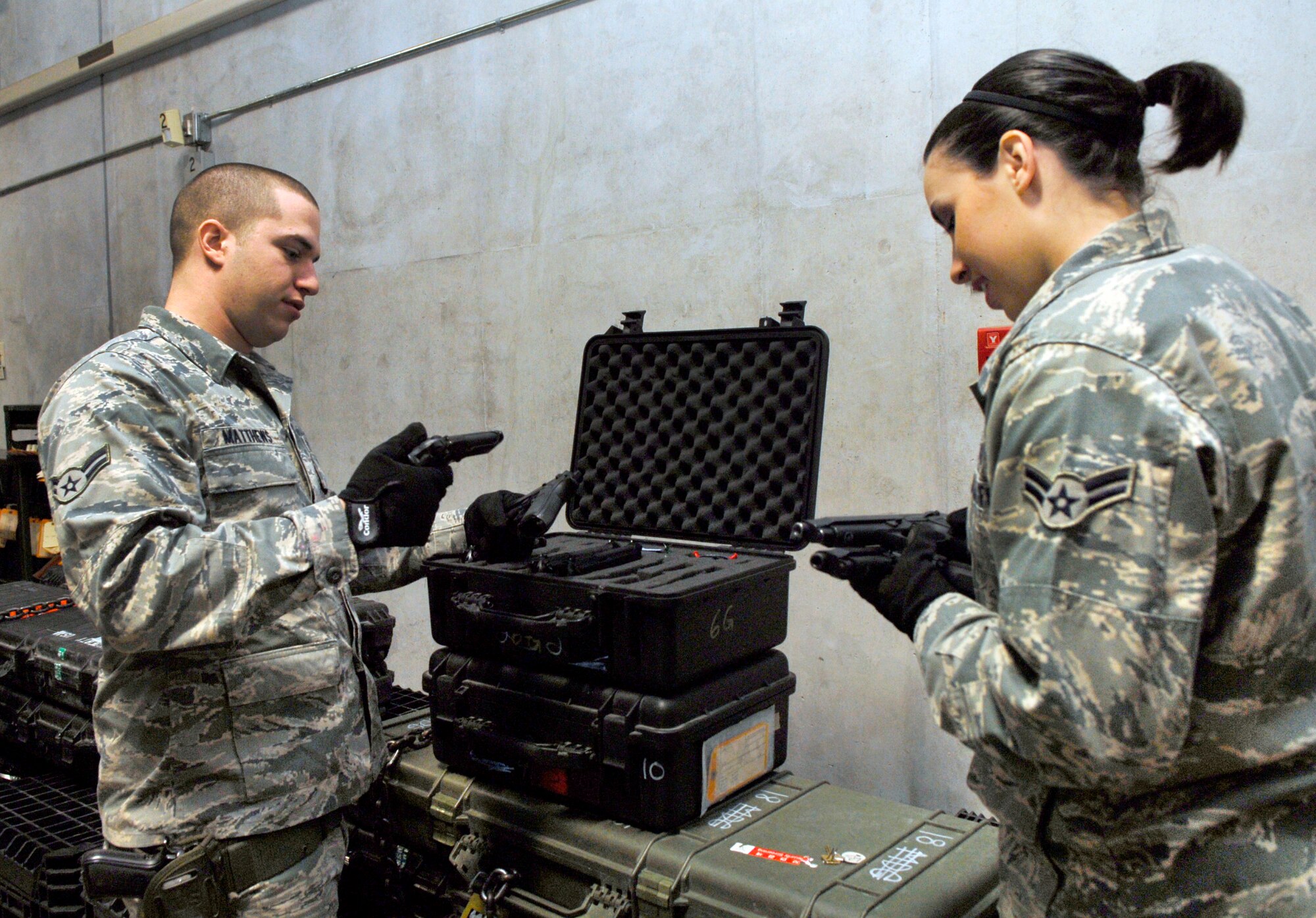 Airman 1st Class Jeri Emmens and Airman 1st Class Tyler Matthews, weapons custodians with the 18th Logistics Readiness Squadron, examine weapons to prepare for the upcoming LORE Jan. 18-22. LRS provides weapons for all Kadena Airmen when they are scheduled to deploy. (U.S. Air Force photo/ Airman 1st Class Tara A. Williamson)