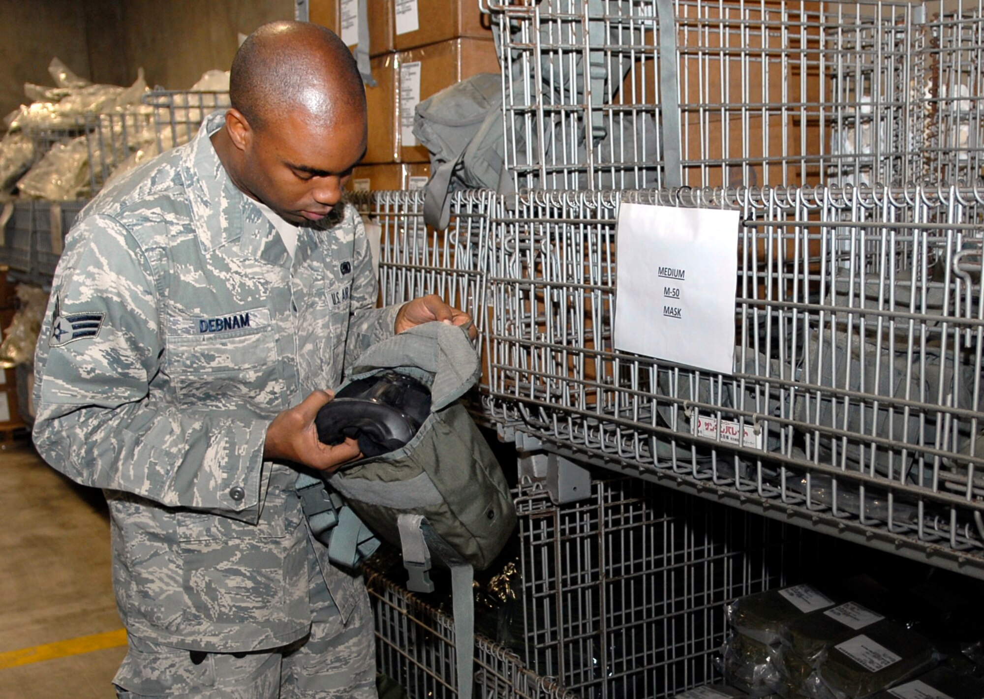 Senior Airman Michael Debnam, individual protection equipment technician with the 18th Logistics Readiness Squadron, performs a check on a gas mask while preparing mobility bags for first term Airmen Jan. 4. The new Airmen will be participating in the upcoming LORE Jan. 18-22. (U.S. Air Force photo/ Airman 1st Class Tara A. Williamson)