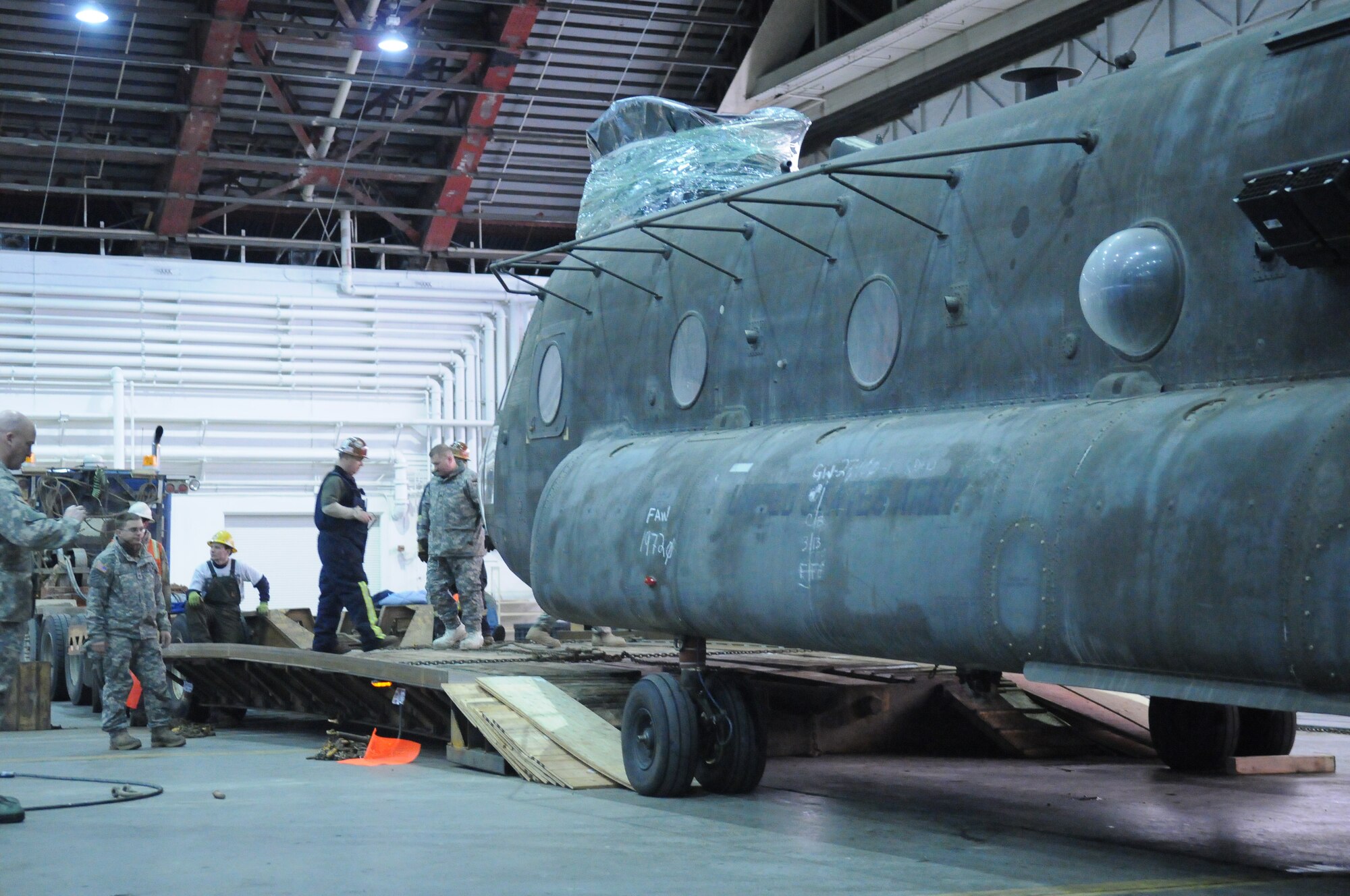 Soldiers load a CH-47 Chinook helicopter onto a specially built trailer Dec. 15, 2010, Eielson Air Force Base. After its delivery by C-17 Globemaster, Soldiers were assisted by Airmen to move the Chinook to Fort Wainwright. The soldiers are assigned to the 16th Combat Aviation Brigade. (U.S. Air Force photo/ Airman 1st Class Janine Thibault)