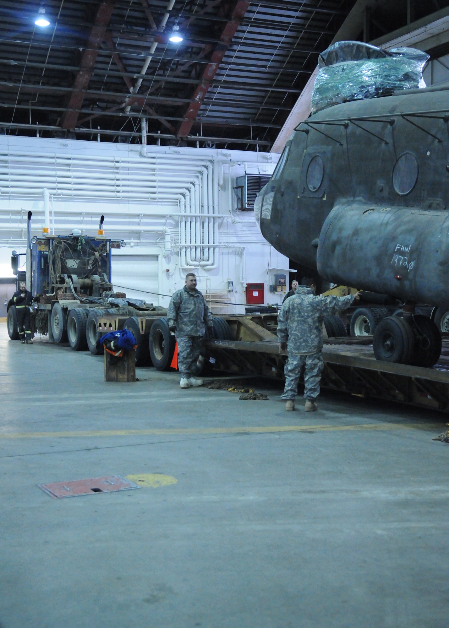Soldiers load a CH-47 Chinook helicopter onto a specially built trailer Dec. 15, 2010, Eielson Air Force Base. After its delivery by C-17 Globemaster, Soldiers were assisted by Airmen to move the Chinook to Fort Wainwright. The soldiers are assigned to the 16th Combat Aviation Brigade. (U.S. Air Force photo/ Airman 1st Class Janine Thibault)