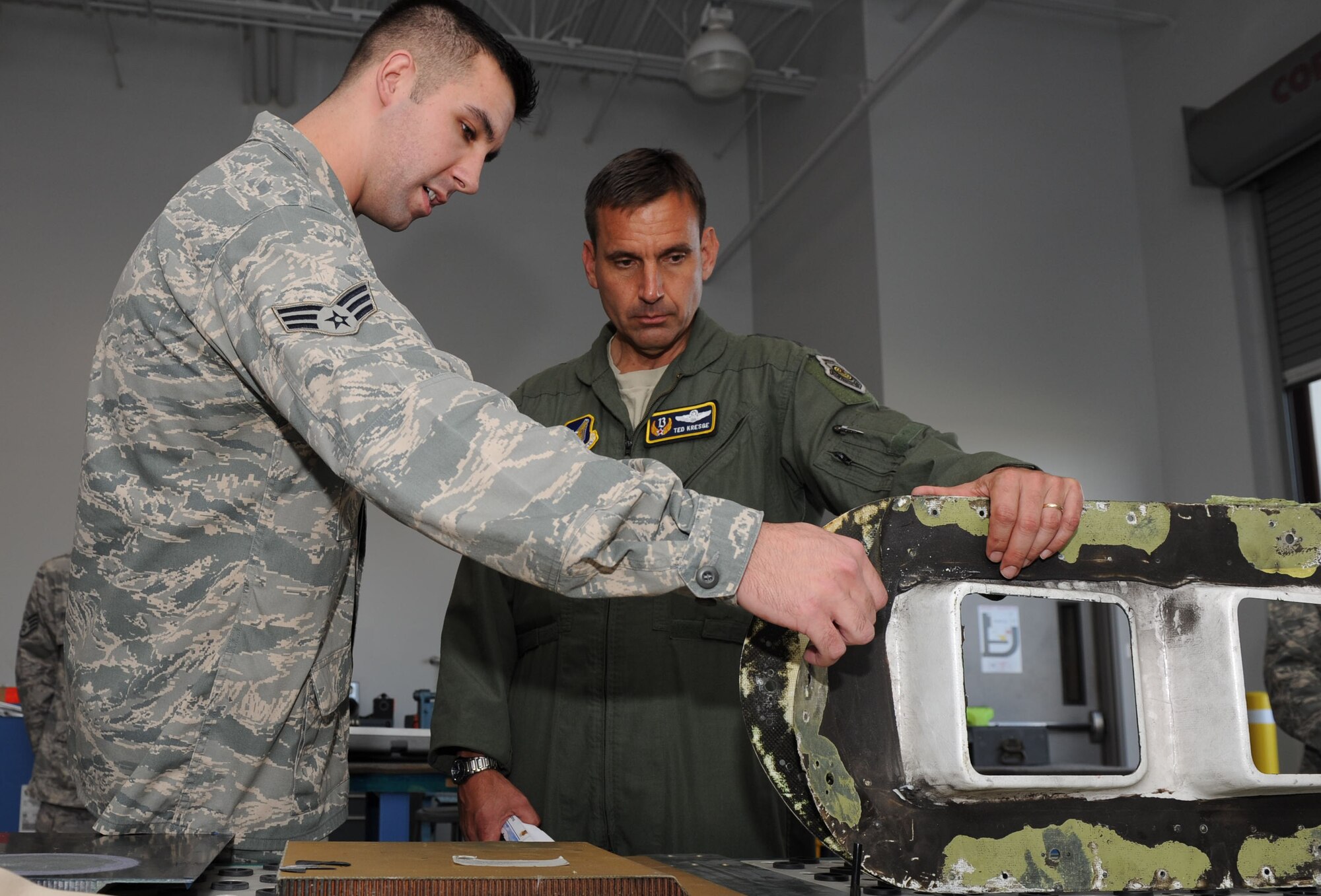 Senior Airman Ryan Dinse, an Aircraft Structural Maintenance apprentice, briefs Lt. Gen. Ted Kresge, 13th Air Force commander, on a defective aircraft component during his visit to the 15th Maintenance Group at the 15th Wing Jan. 4. General Kresge met with Airmen and learned the mission and functions of various units here during his visit to the wing.  (U.S. Air Force photo/Airman 1st Class Lauren Main)