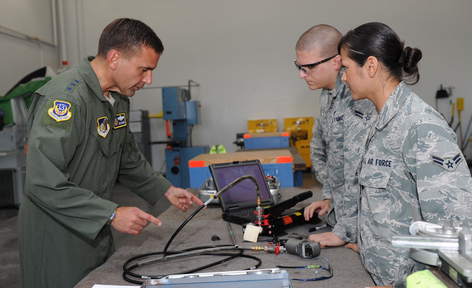 Lt. Gen. Ted Kresge, 13th Air Force commander, asks job related questions to Airman 1st Class Gabriela Lopez and Airman 1st Class Jeremy Billiot, Aircraft Structural Maintenance journeymen with the 15th Maintenance Squadron, during a visit to the 15th Maintenance Group at the 15th Wing Jan. 4. General Kresge met with Airmen and learned the mission and functions of various units here during his visit to the wing. (U.S. Air Force photo/Airman 1st Class Lauren Main)
