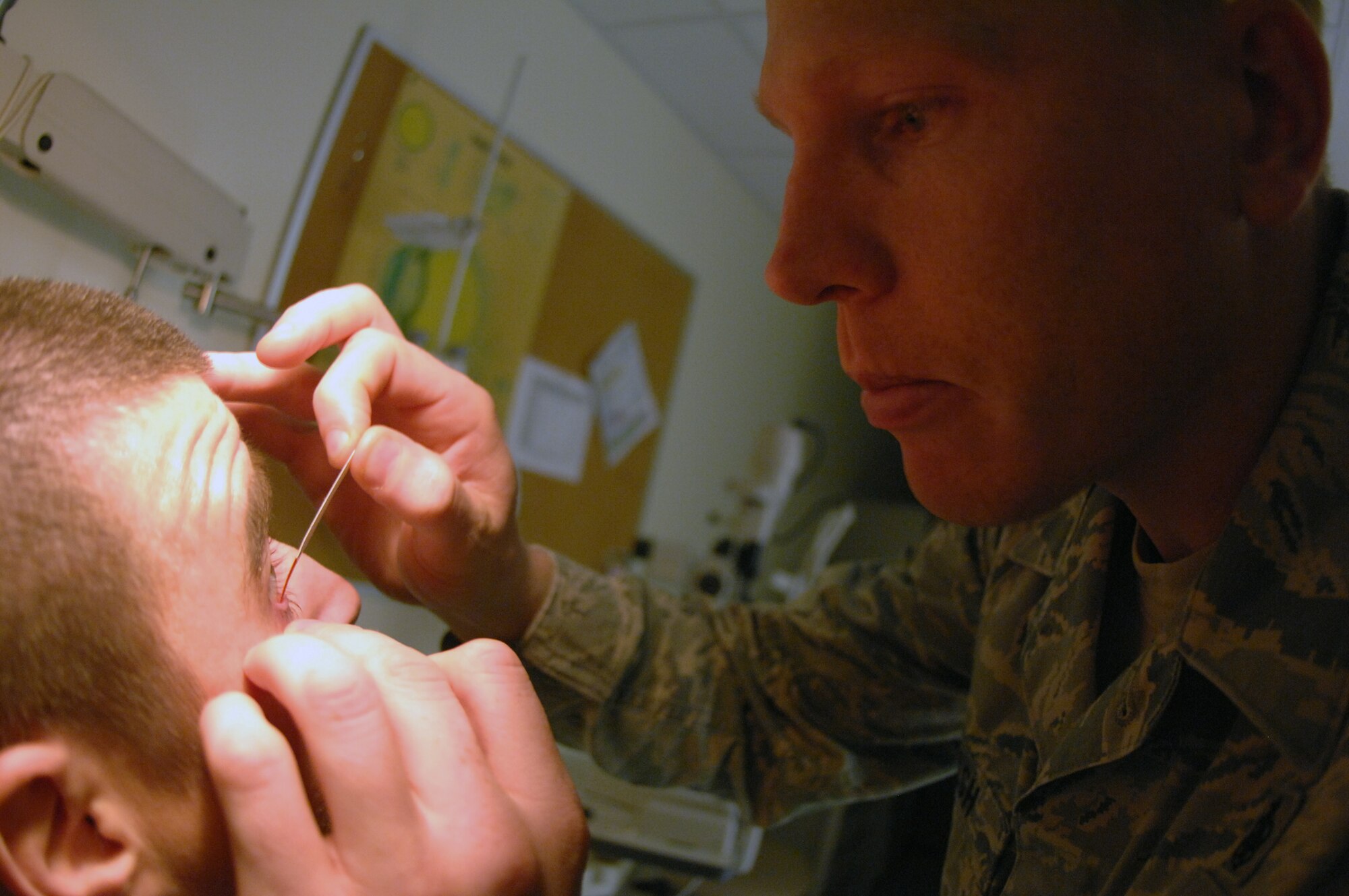 TSgt. Josh Karash, 36th Medical Operations Squadron Optometry NCO in charge, conducts an eye exam on a patient at the 36 MDOS optometry clinic, Jan. 4. The technicians use tools such as visual field analyzers, non-contact tenometers, retina cameras and corneal topographers to identify the dimensions of the patient’s eye and determine a prescription if needed. The clinic performs full-scope primary eye care for all active duty members, their dependents and retirees. (U.S. Air Force photo/ Airman 1st Class Anthony Jennings)