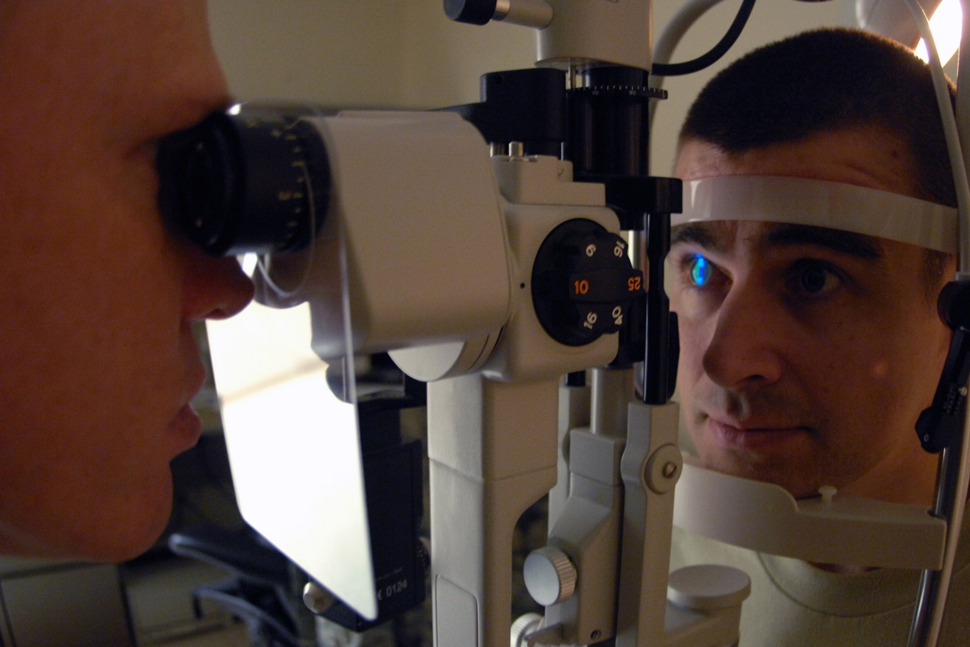 TSgt. Josh Karash, 36th Medical Operations Squadron Optometry NCO in charge, conducts an eye exam on a patient at the 36 MDOS optometry clinic, Jan. 4. The technicians use tools such as visual field analyzers, non-contact tenometers, retina cameras and corneal topographers to identify the dimensions of the patient’s eye and determine a prescription if needed. The clinic performs full-scope primary eye care for all active duty members, their dependents and retirees. (U.S. Air Force photo/ Airman 1st Class Anthony Jennings)