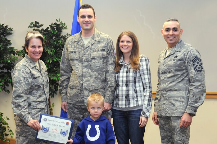 Col. Martha Meeker, left, and Chief Master Sgt. Jose LugoSantiago, right, present a certificate to Tech. Sgt. Justin Steidler, joined by his wife Aimee and son Gavin, during the December monthly promotion ceremony at the Charleston Club Dec. 30, 2010. Sergeant Steidler received his promotion through the Stripes for Exceptional Performers program. Colonel Meeker is the 628th Air Base Wing commander, Chief LugoSantiago is the 628 ABW command chief and Sergeant Steidler is assigned to the 628th Medical Group. (U.S. Air Force photo/Staff Sgt. Marie Brown)