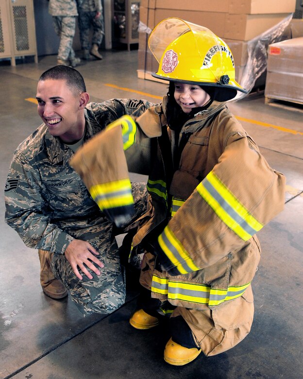 DAVIS-MONTHAN AIR FORCE BASE, Ariz. - Staff Sgt. Cole Connors, a firefighter from the 355th Civil Engineer Squadron, smiles alongside Pilot for a Day participant Chenoa Richner, 7, on her tour of the D-M Fire Department here Dec. 29. As part of her tour, Chenoa and her family visited the 354th Fighter Squadron, the air traffic control tower, the D-M Fire Department and several aircraft static displays. (U.S. Air Force photo/Airman 1st Class Michael Washburn)