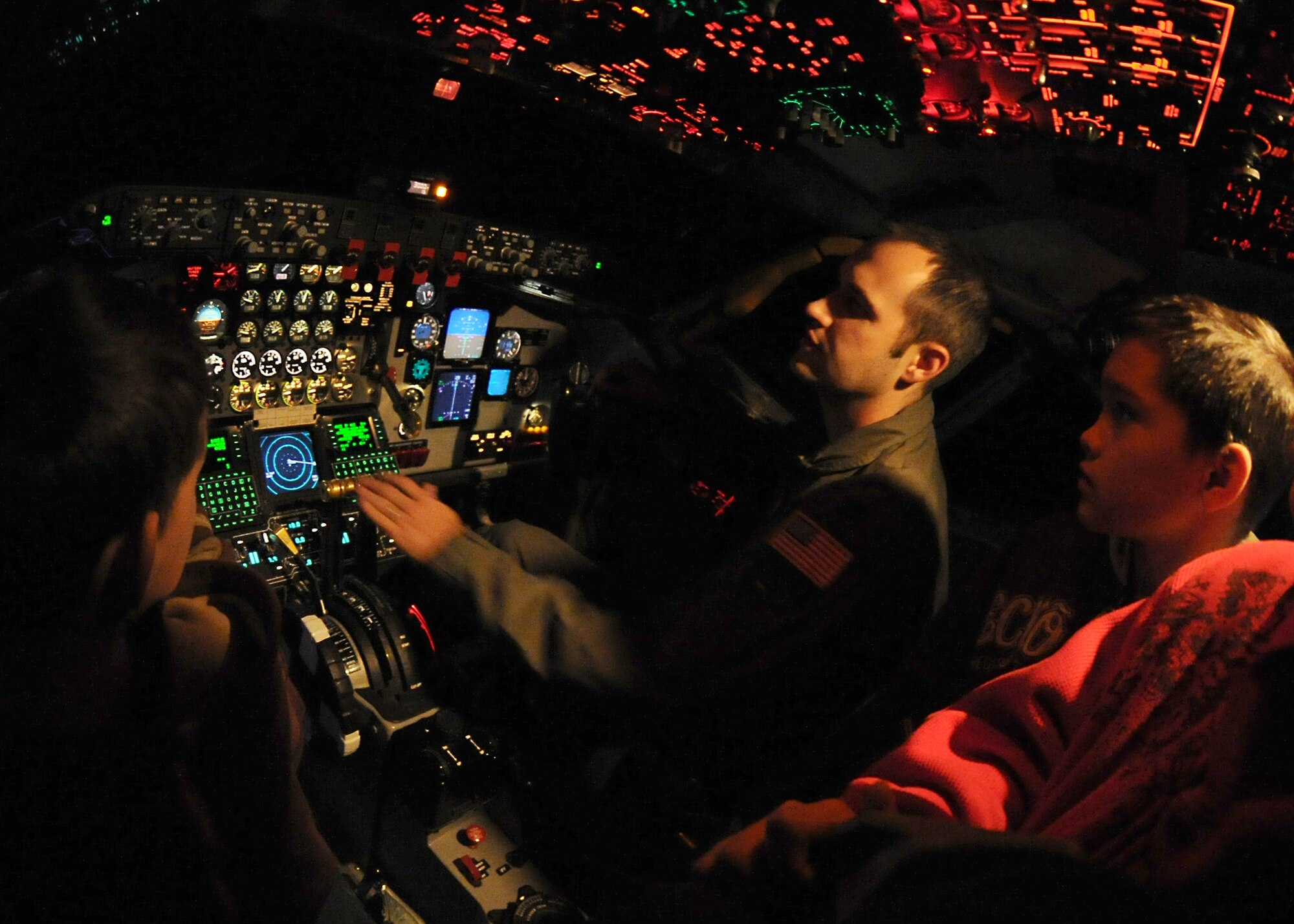 Capt. Jonathan Christopher, 349th Air Refueling Squadron instructor pilot, describes the navigational controls of a KC-135 Stratotanker simulator to 11-year-old “littles,” Alfredo Edmonds and Arturo Mendez from the Big Brothers Big Sisters of Sedgwick County, Dec. 22, 2010, McConnell Air Force Base, Kan. The 349th ARS hosted the BBBS event for 29 littles, to provide a firsthand experience of base operations. The Kansas BBBS assists more than 6,000 Kansas boys and girls, most of whom are considered at-risk or live in single parent homes, achieve their full potential through long-term personal relationships with carefully screened volunteers. (U.S. Air Force photo/Senior Airman Maria A. Ruiz)