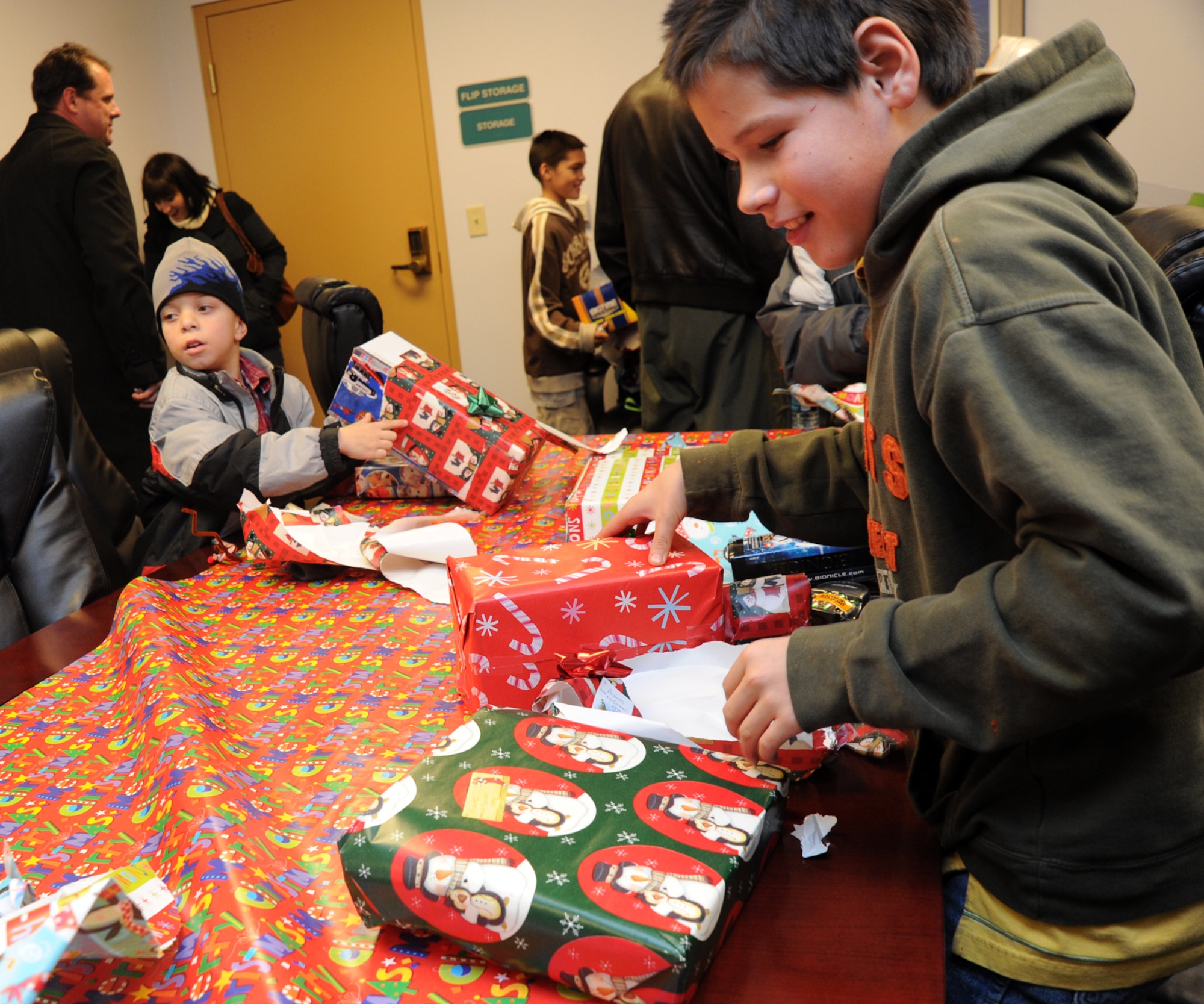 Andres, 11, a “little” from Big Brothers Big Sisters of Sedgwick County, opens gifts he received during a BBBS Operation Santa-135, Dec. 22, 2010, McConnell Air Force Base, Kan.  Twenty-nine “littles” toured the base and received a surprise visit from Santa, and several gifts.  (U.S. Air Force photo/Airman 1st Class Andrea Salazar)