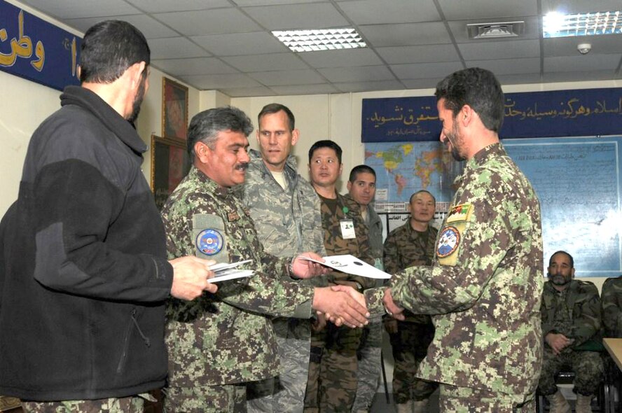 An Afghan air force airman receives a certificate for graduating from the Mi-17 helicopter engine and body maintenance course Jan. 1, 2011, at the Afghan Air Force Base in Kabul, Afghanistan. The graduates became the first airmen to complete the course. (U.S. Navy photo/Petty Officer 2nd Class Vladimir Potapenko)
