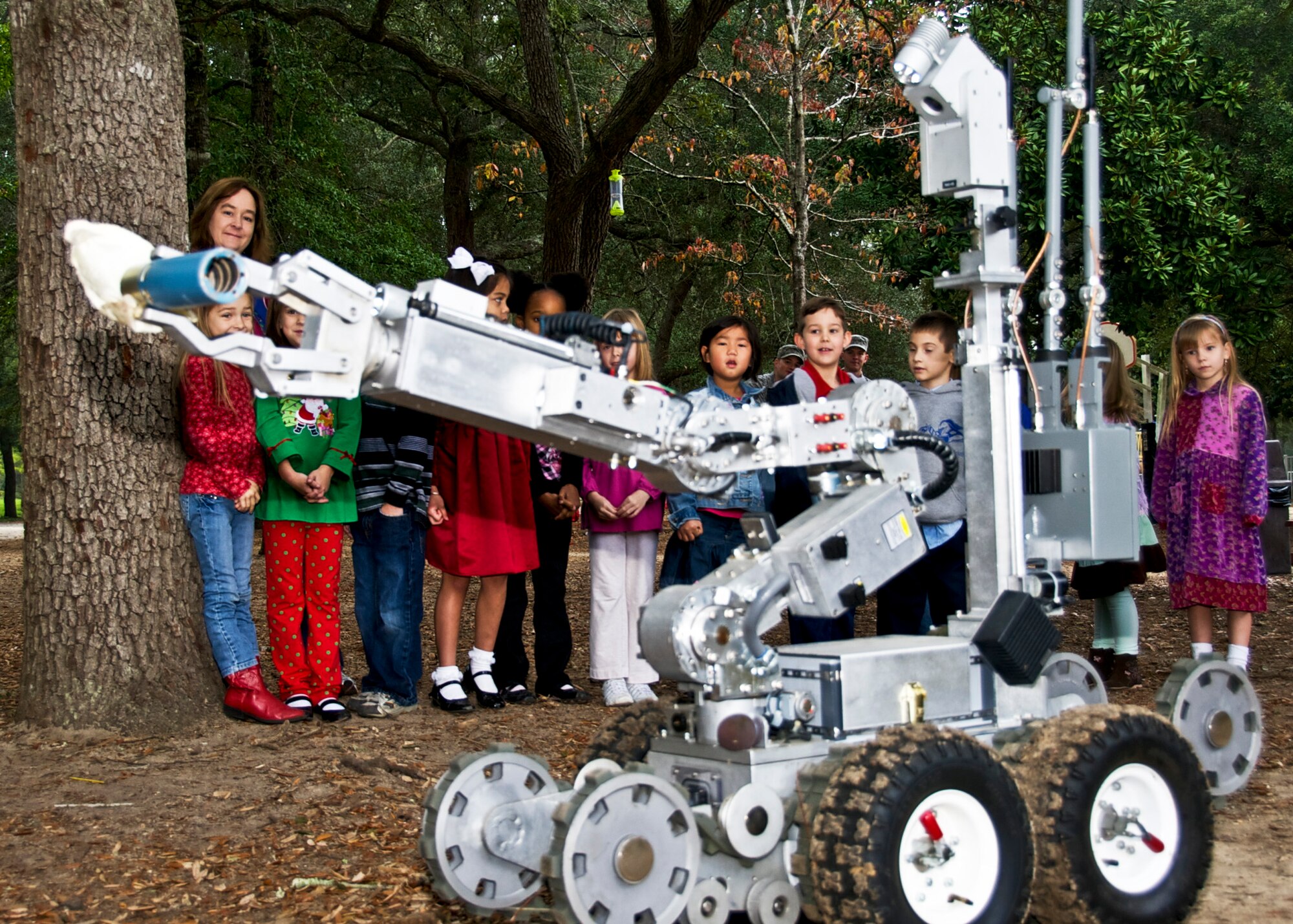 First grade students look on as the Explosive Ordnance Disposal’s Remotec Andros F6A robot lifts a container off the ground at Rocky Bayou Christian School Dec. 17. Tech. Sgt Steven Bailey, 366th Training Squadron, Det.3, served as a Friday mystery guest for the 1st grade class, where his daughter is a student. (U.S. Air Force photo/Sachel Seabrook)
