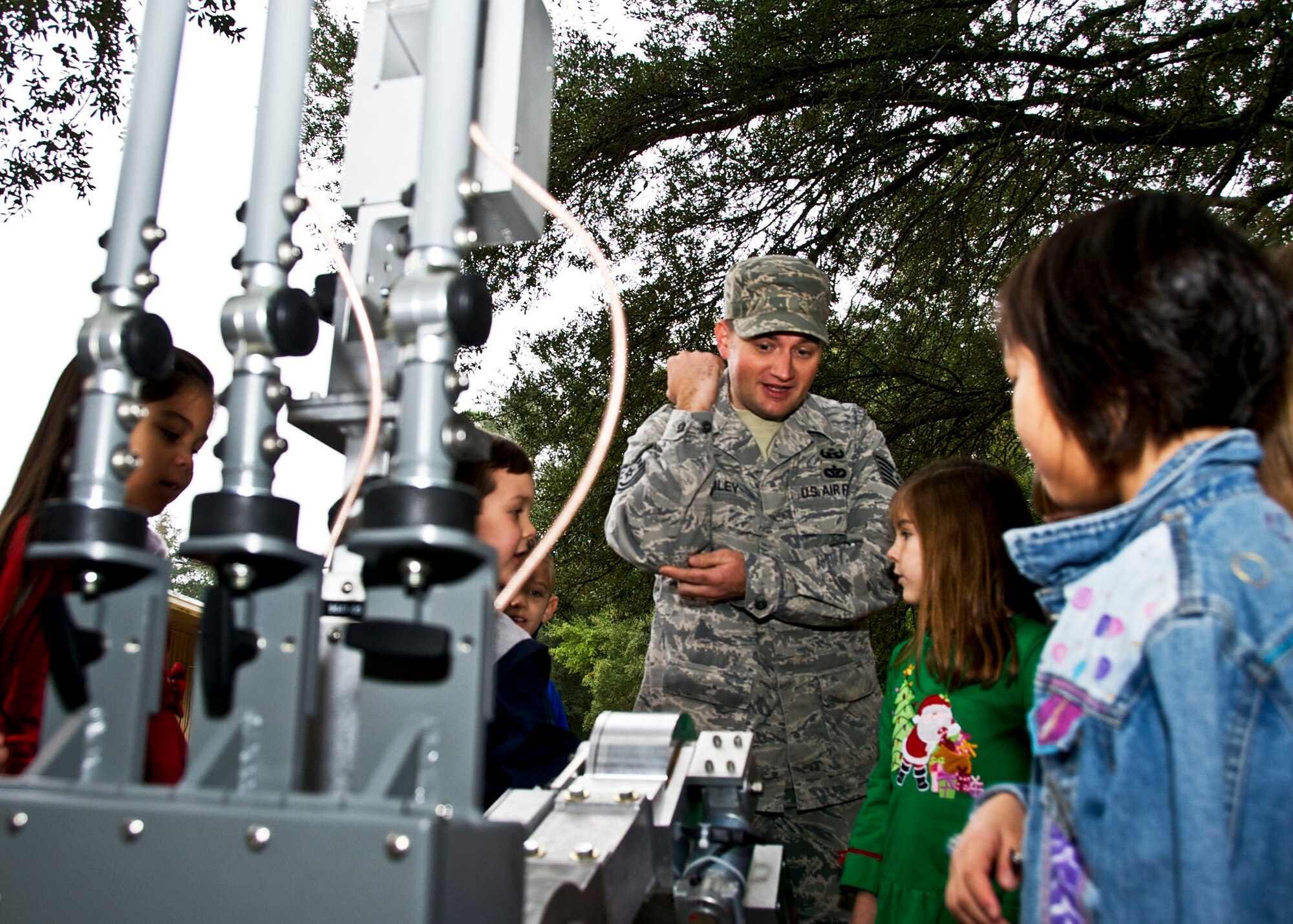 Tech. Sgt. Steven Bailey, 366th Training Squadron, Det.3, shows students how the arms of the Remotec Andros F6A robot move at Rocky Bayou Christian School Dec. 17. The Explosive Ordnance Disposal instructor served as a Friday mystery guest for the 1st grade class, where his daughter is a student. (U.S. Air Force photo/Sachel Seabrook)