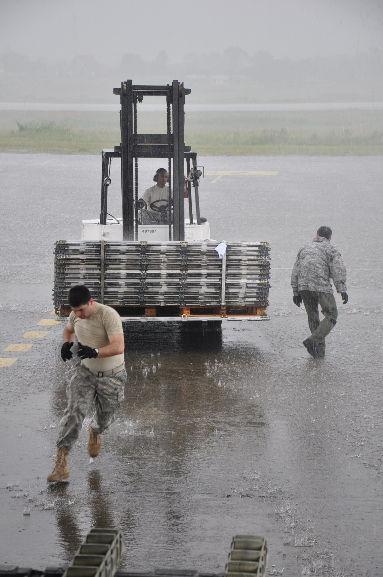 Aerial porters otherwise known as "Port Dawgs" from the 81st Aerial Port Squadron, Joint Base Charleston, S.C., get the job done rain or shine while loading empty pallets aboard a C-17 Globemaster III before leaving Panama during a training and humanitarian mission to Haiti and Grenada Dec. 30, 2010. (U.S. Air Force photo/Senior Airman Robert Pilch)