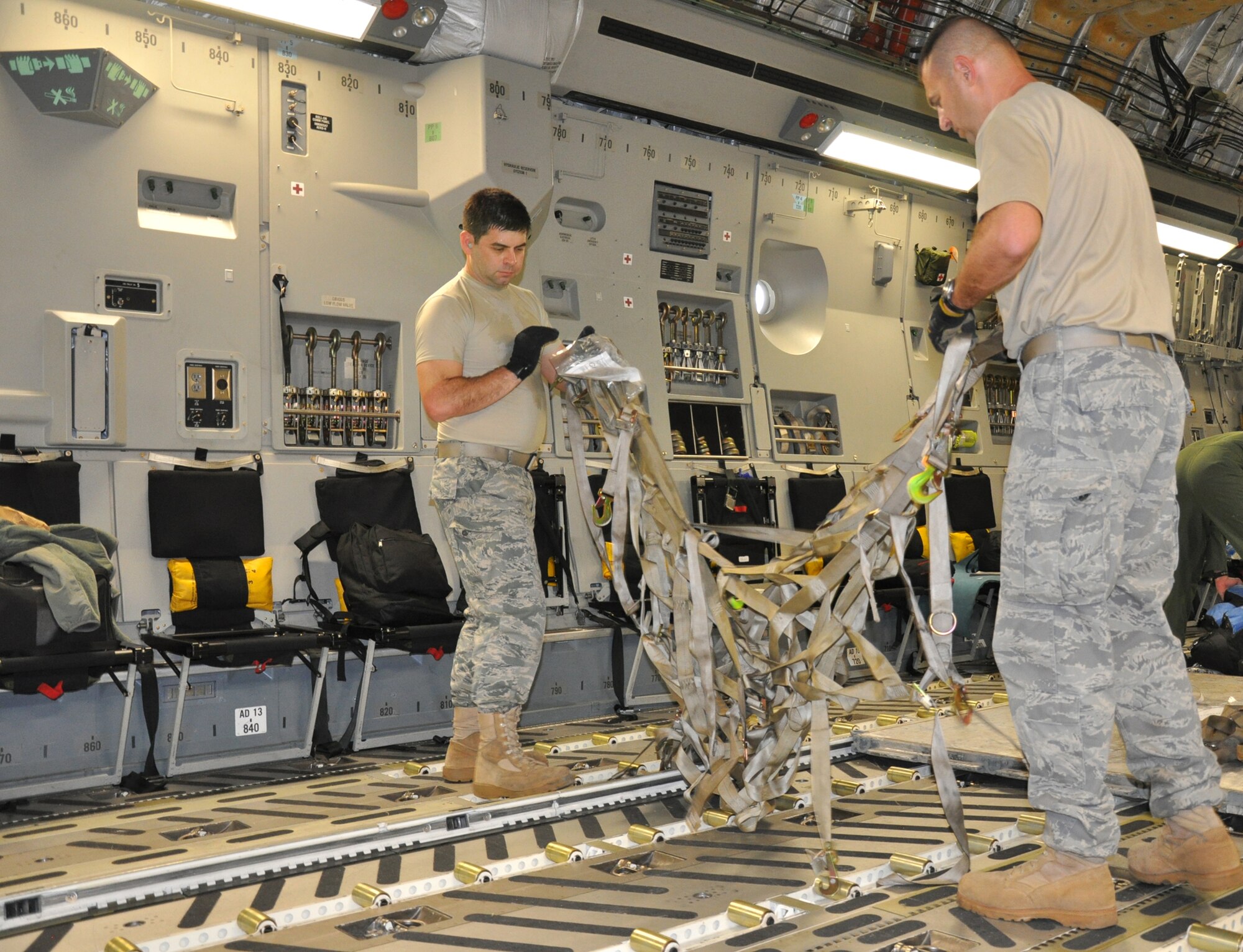 Tech. Sgt. Alvin Casiano and Master Sgt. Randal Pickenpaugh with the 81st Aerial Port Squadron, JB CHS, S.C., prepare a cargo net for transport during a humanitarian aid and training mission Dec. 30, 2010. (U.S. Air Force photo/Senior Airman Robert Pilch)