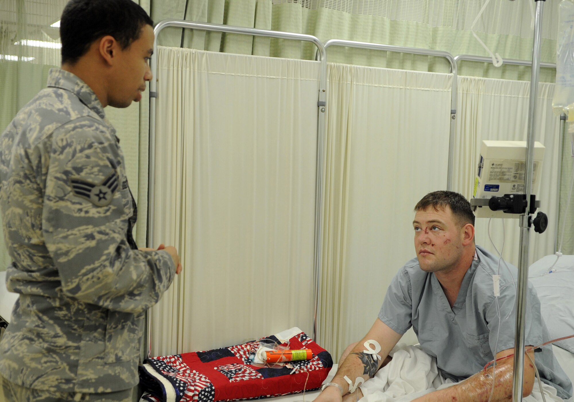 JOINT BASE BALAD, Iraq -- U.S. Air Force Senior Airman Greg Rodgers, left, 332nd Expeditionary Medical Operations Squadron medical technician, visits recent Purple Heart recipient U.S. Army Cpl. Paul Vanlinder, Charlie Company 1-21 Infantry Battalion, Jan. 4, 2011. The Fulton, N.Y., native was admitted to the intensive care unit here after being involved in an improvised explosive device attack near Abu Sayada, Iraq. Airman Rodgers is a native of Little Rock, Ark., and is deployed from Lackland Air Force Base, Texas. (U.S. Air Force photo/ Staff Sgt. Keyonna Fennell)