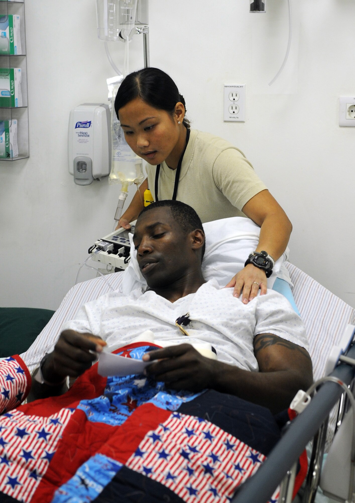JOINT BASE BALAD, Iraq- - U.S. Air Force Staff Sgt. Frances Robinson, 332nd Expeditionary Medical Operations Squadron medical technician, comforts U.S. Army 1st Lt. Corey Bunch, Charlie Company 1-21 Infantry Battalion Jan. 4, 2011. The Brooklyn, N.Y., native was admitted to the intensive care unit here after being involved in an improvised explosive device attack near Abu Sayada, Iraq. Sergeant Robinson is deployed from Joint Base Andrews Naval Air Facility Washington, Md. (U.S. Air Force photo/ Staff Sgt. Keyonna Fennell)