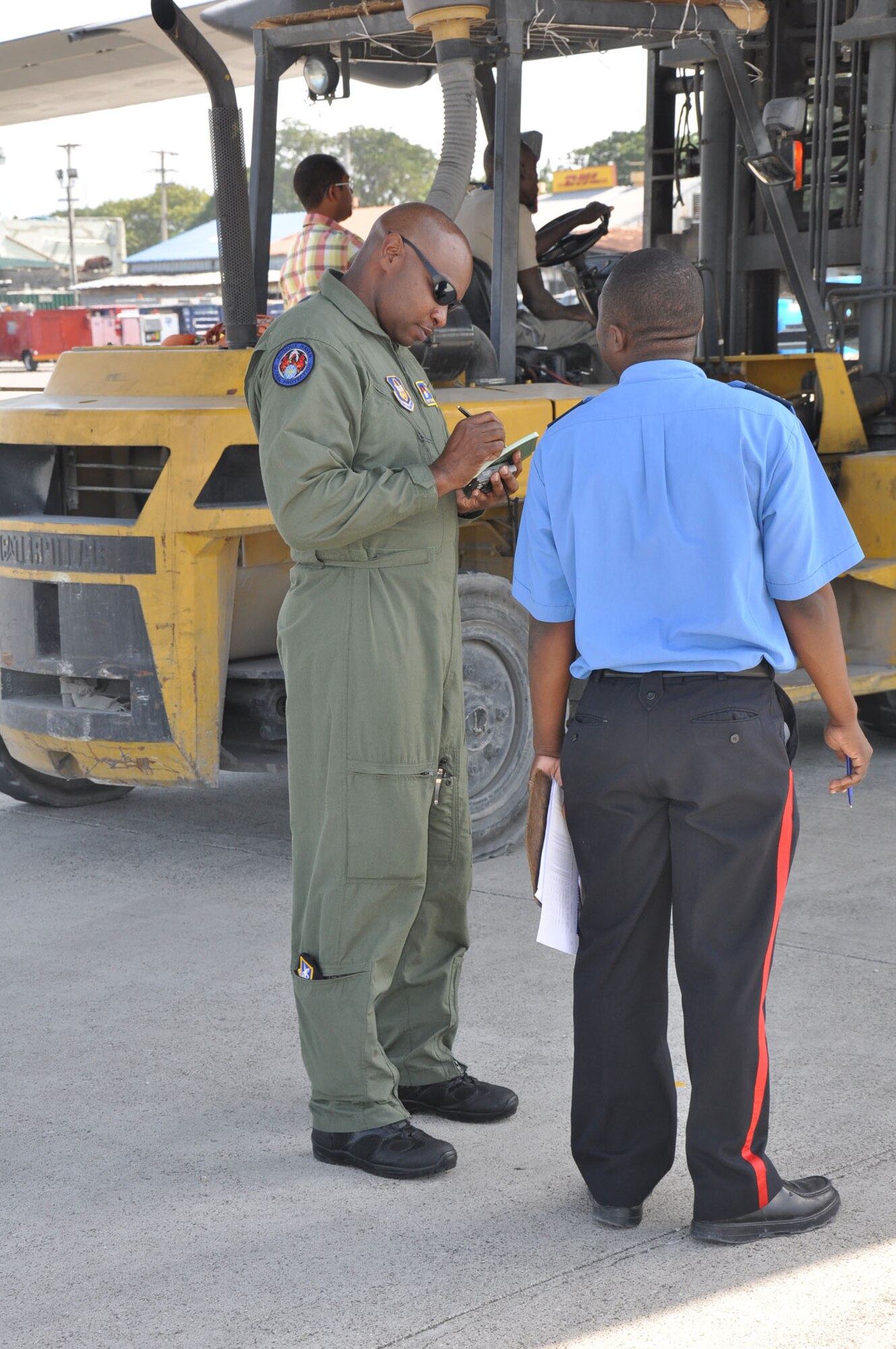Tech. Sgt. Darrien S. Thornton, a RAVEN program manager with the 94th Security Forces Squadron, Dobbins Air Reserve Base, Ga., meets with a member from Haiti Customs while securing a C-17 Globemaster III aircraft during a humanitarian aid mission to Haiti and Grenada Dec. 30, 2010. (U.S. Air Force photo/Senior Airman Robert Pilch) 