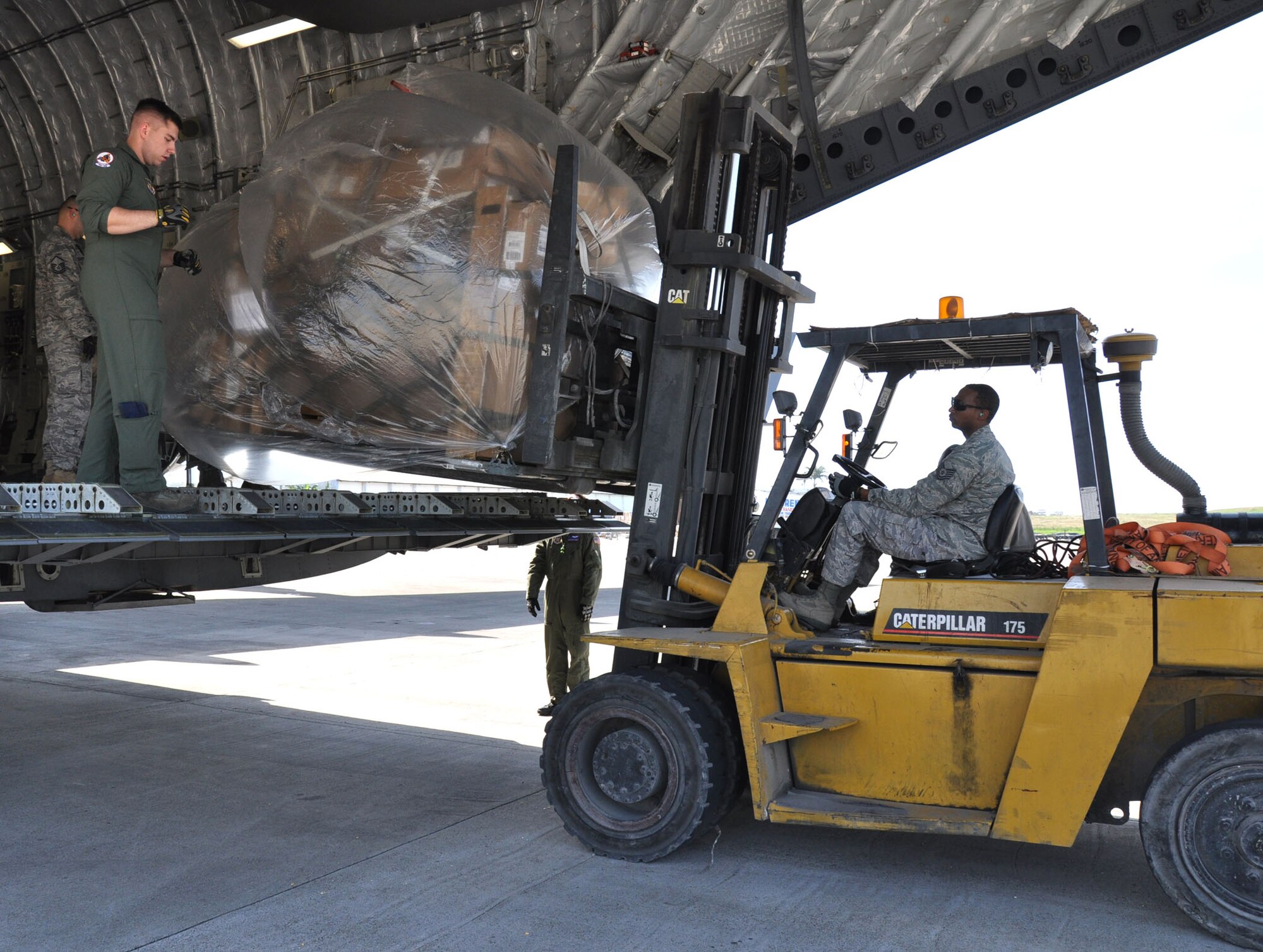 Senior Airman Cody Rogers and Tech. Sgt. Darrius Warren from the 315th Airlift Wing, Joint Base Charleston, S.C. offload aid from a C-17 Globemaster III aircraft during a humanitarian aid mission to Haiti and Grenada Dec. 30, 2010. (U.S. Air Force photo/Senior Airman Robert Pilch)