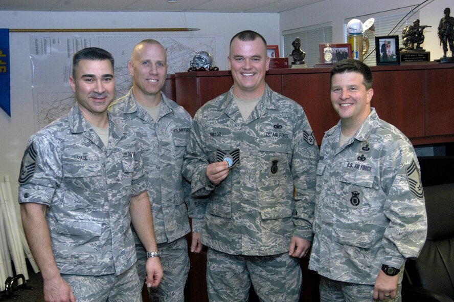 Staff Sgt. Luke Bistor of the 88th Security Forces Squadron holds his new stripes and an Aeronautical Systems Center coin following his surprise promotion to Technical Sgt. Dec. 21, 2010 at Wright-Patterson Air Force Base, Ohio.  Pictured with Sergeant Bistor are Chief Master Sgt. Edward Pace, Chief Master Sgt. Todd Osier, and Chief Master Sgt. James Johnson. Lt. Gen. Thomas Owen, commander of Aeronautical Systems Center, promoted Sergeant Bistor via the Stripes for Exceptional Performers program. Chief Pace is is superintendent of the 88th Medical Group and acting command chief for ASC and the 88th Air Base Wing, Chief Osier is superintendent of the 88th Mission Support Group, and Chief Johnson is manager of the 88th Security Forces Squadron. (U.S. Air Force photo/Derek Kaufman)