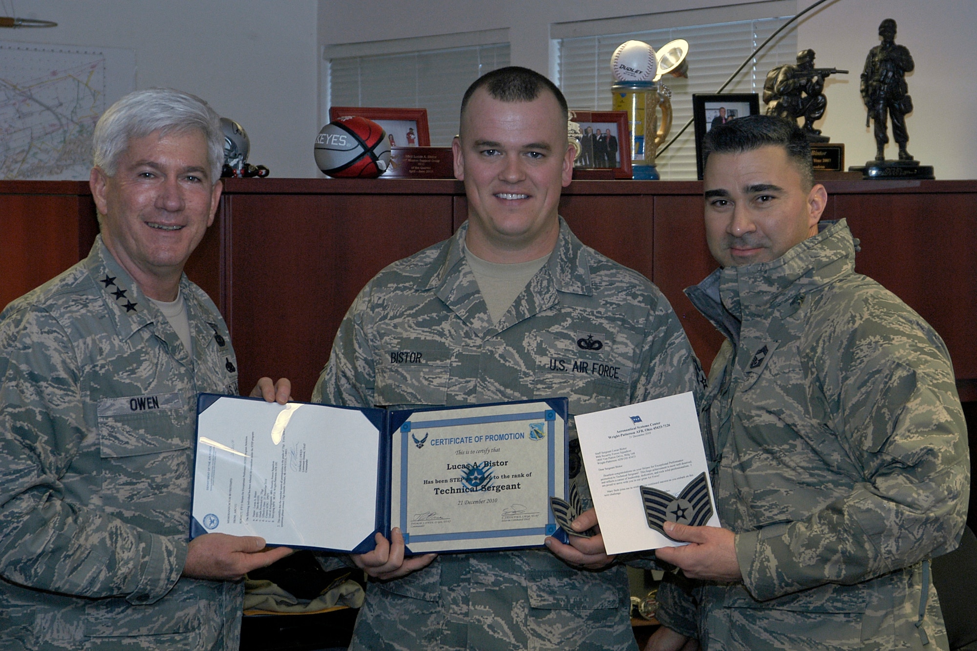 Lt. Gen. Thomas Owen and Chief Master Sgt. Edward Pace congratulate Staff Sgt. Luke Bistor of the 88th Security Forces Squadron following his surprise promotion to Technical Sgt. Dec. 21, 2010 at Wright-Patterson Air Force Base, Ohio.  General Owen promoted Sergeant Bistor via the Stripes for Exceptional Performers program. General Owen is commander of Aeronautical Systems Center and Chief Pace is superintendent of the 88th Medical Group and acting command chief for ASC and the 88th Air Base Wing. (U.S. Air Force photo/Derek Kaufman)