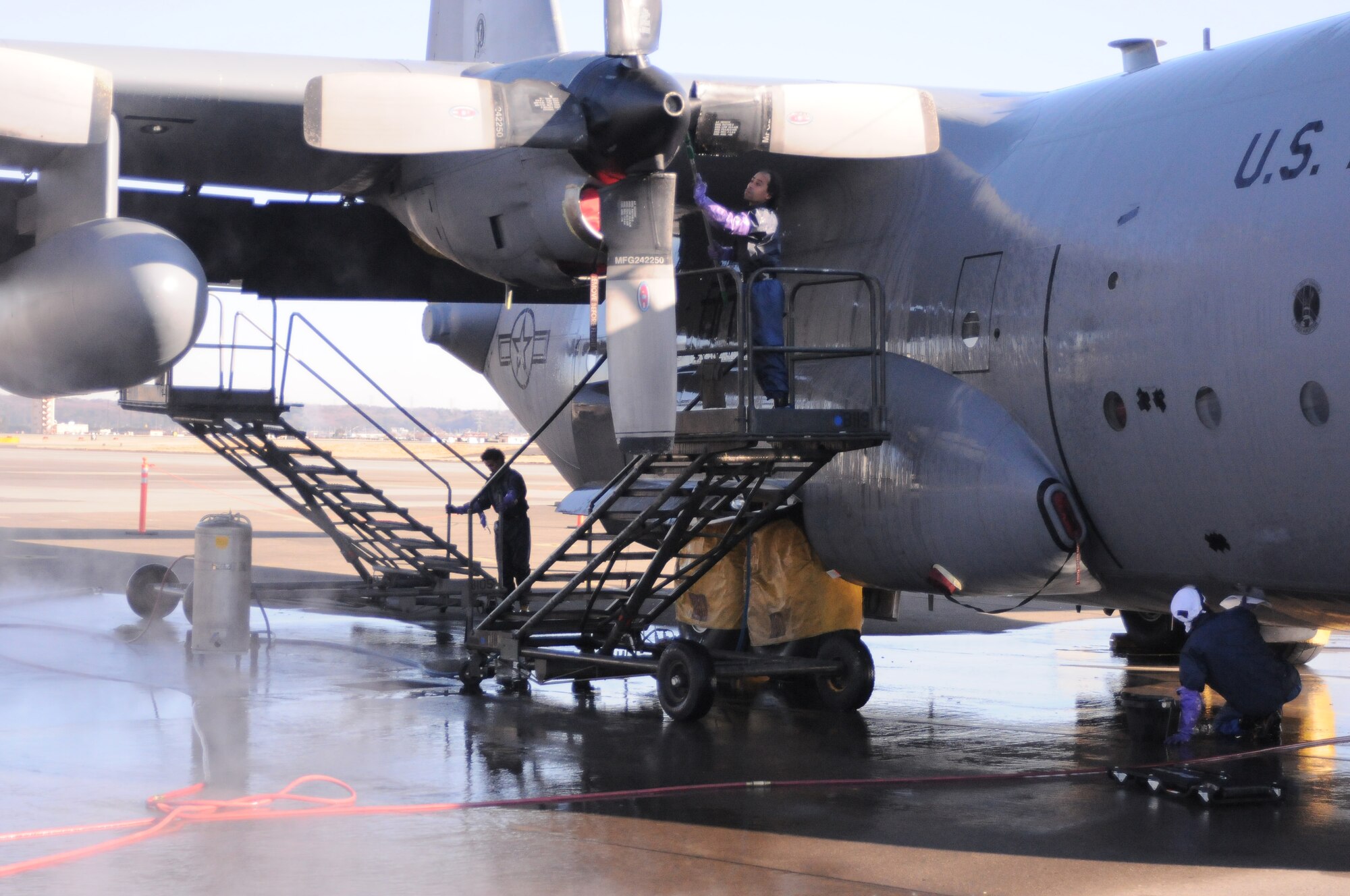 YOKOTA AIR BASE, Japan -- Local nationals wash the exterior of a one of Yokota's C-130 Hercules at the Washrack here Jan. 5. The Washrack is where Yokota's C-130 Hercules aircraft are washed and treated for corrosive materials. (U.S. Air Force photo/ Airman 1st Class Katrina R. Menchaca)