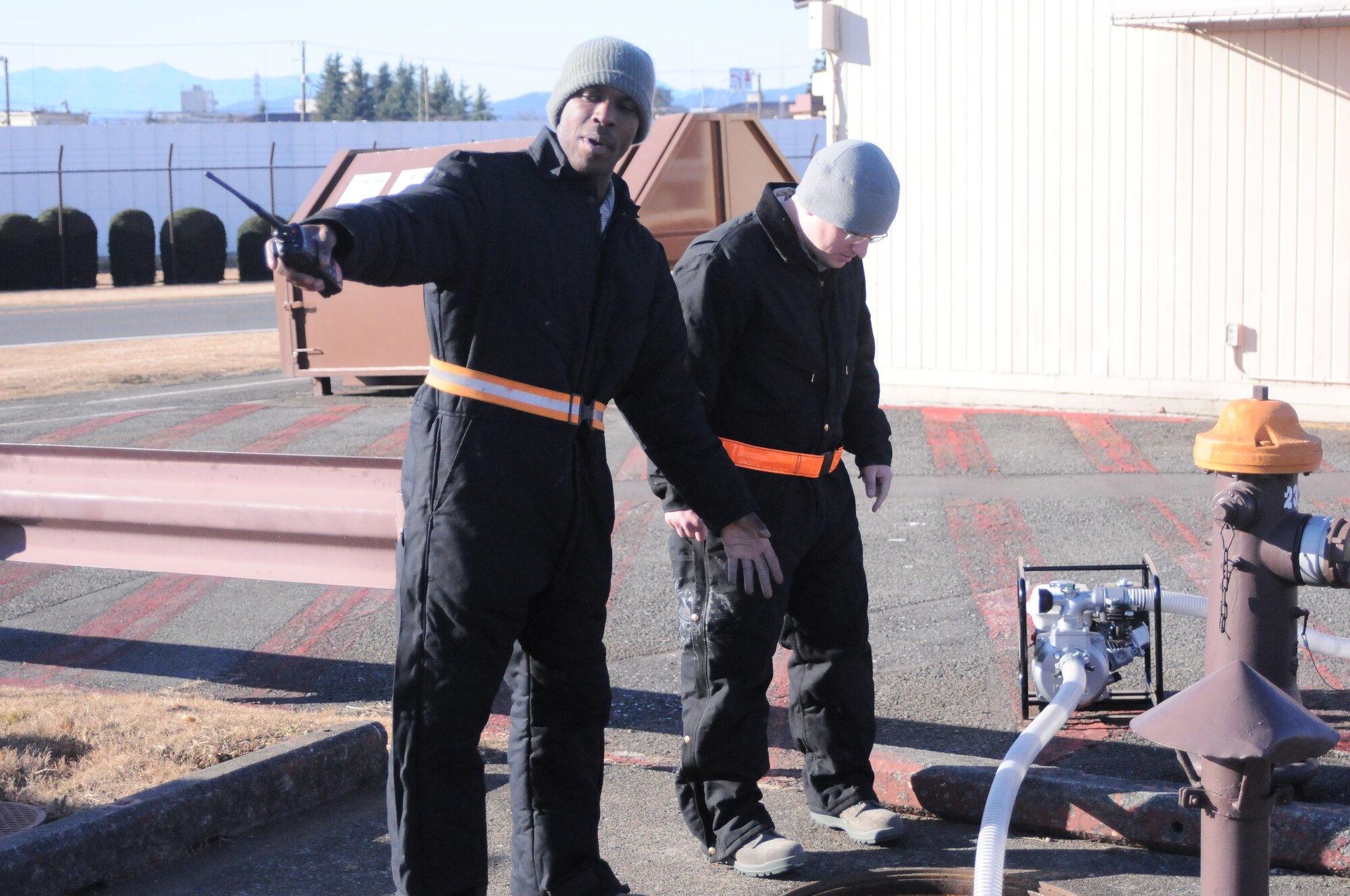 YOKOTA AIR BASE, Japan -- Staff Sgt. Antonio Peals, NCO in charge of the Washrack, explains the workings of the sewage pump to Airman 1st Class Tim Butler, 374th Maintenance Squadron aircraft structural maintainer, here Jan. 5. The Washrack is where Yokota's C-130 Hercules aircraft are washed and treated for corrosive materials. (U.S. Air Force photo/ Airman 1st Class Katrina R. Menchaca)