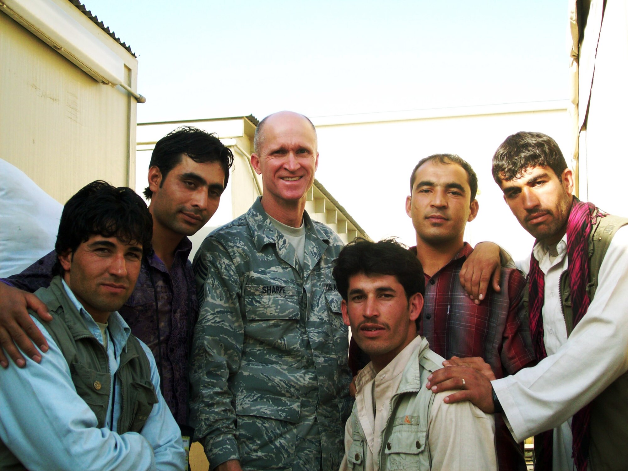 Chief Master Sgt. Bud Sharpe, 36th Civil Engineer Squadron superintendent, poses with Afghan workers that he got to know in over the course of his deployment from April to December 2010 on Bagram Airfield, Afghanistan. Thousands of local workers are employed as custodians, food service professionals and other various occupations on-base. (U.S. Air Force Courtesy Photo)
