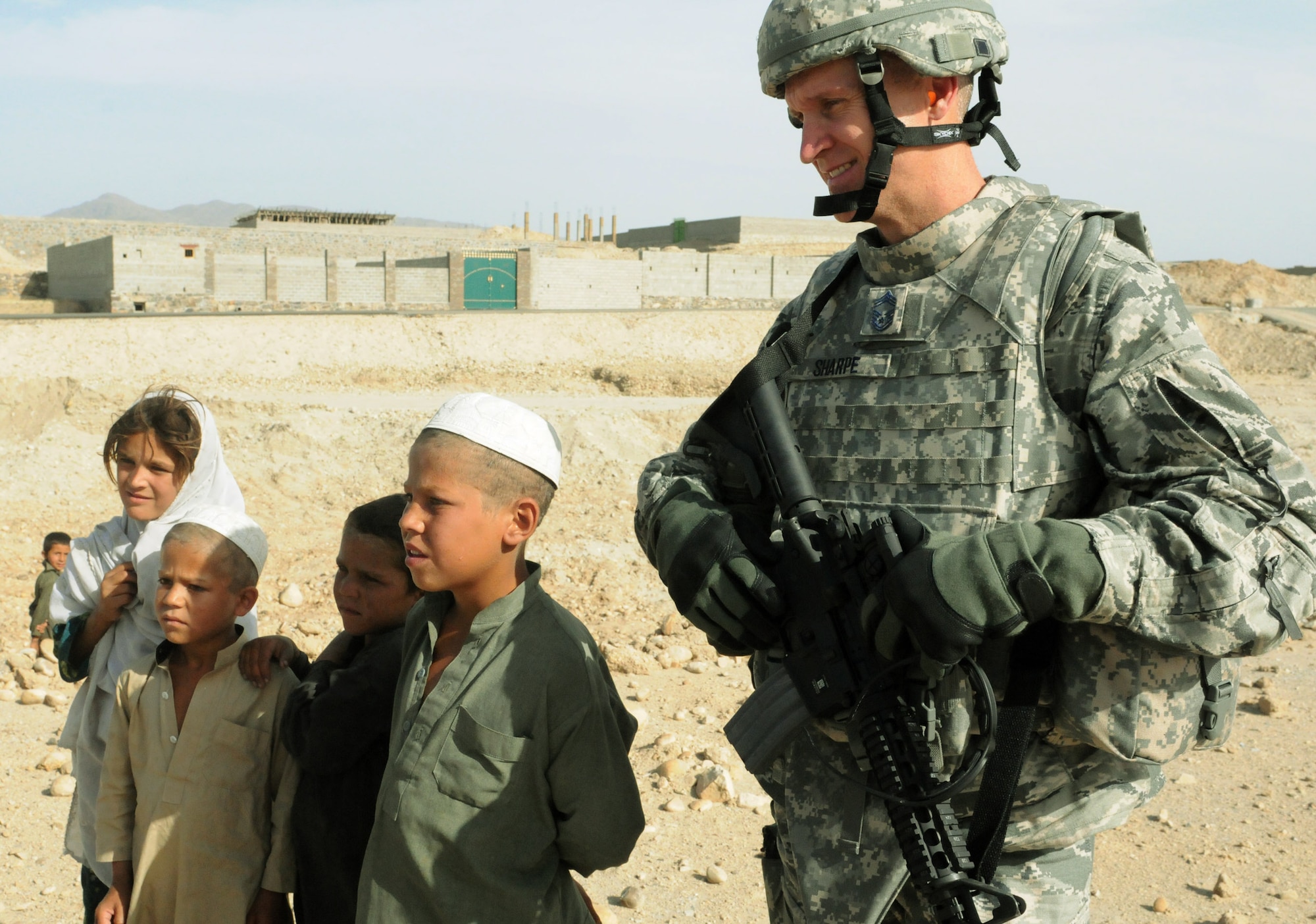 Chief Master Sgt. Bud Sharpe, 36th Civil Engineer Squadron superintendent, gets to know Afghan children in the Metar Lam Province, Afghanistan in late May 2010 after completing work on a new schoolhouse for children in the local villages. (U.S. Air Force Courtesy Photo) 